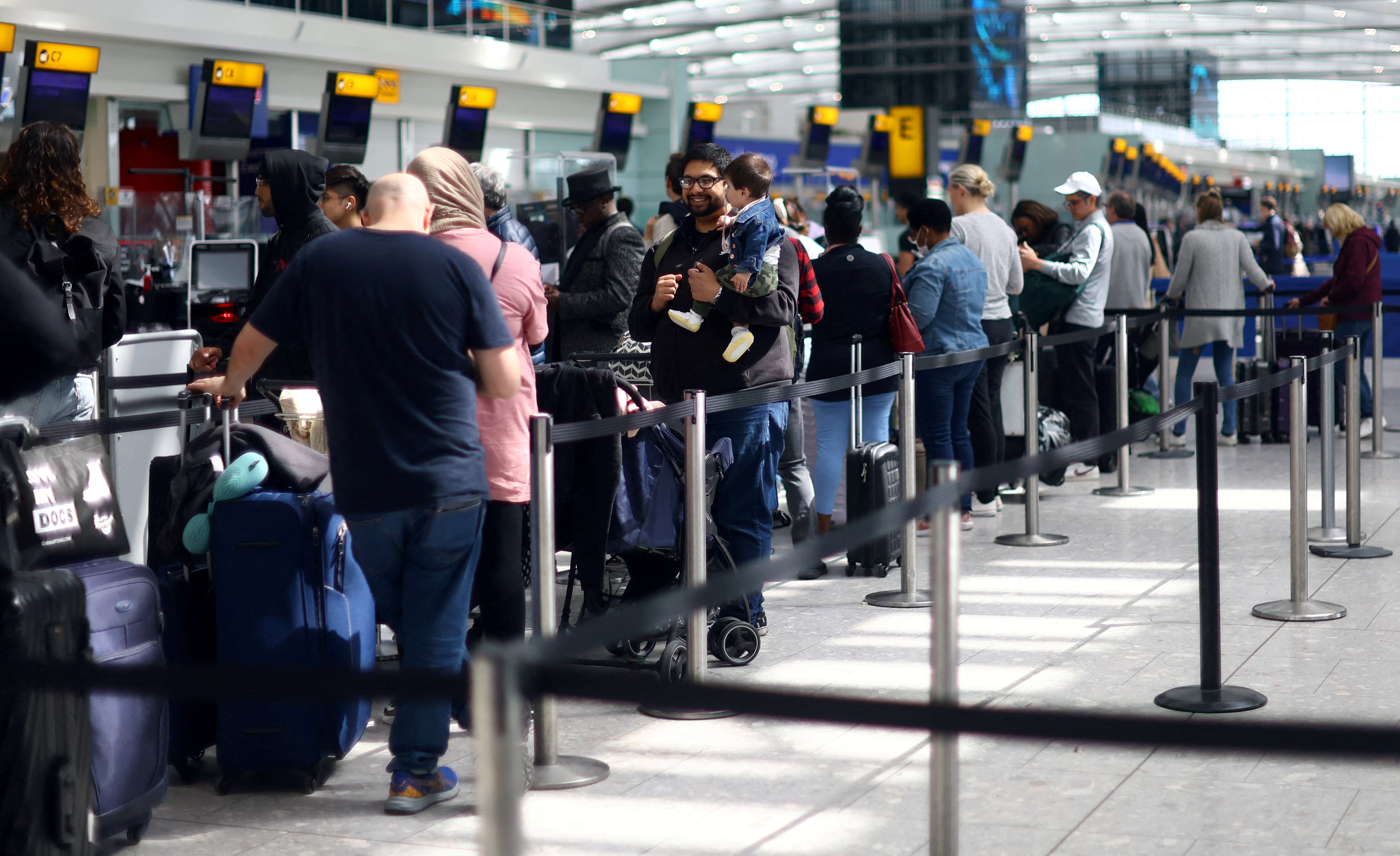 Los pasajeros hacen cola para facturar en la Terminal 5 del aeropuerto de Heathrow, en Londres
