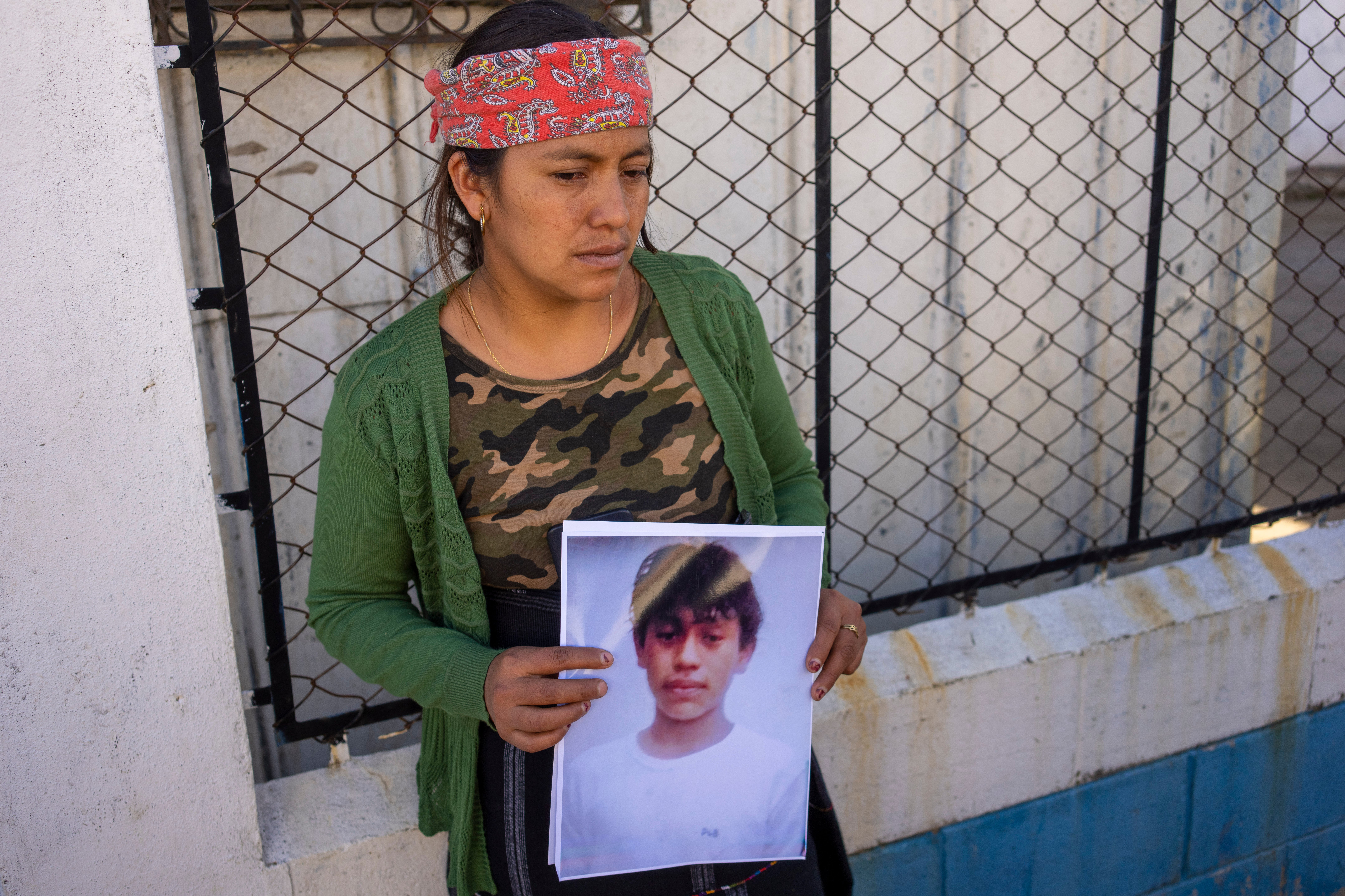 Maria Sipac Coj sostiene un retrato de su hijo Pascual Melvin Guachiac en Tzucubal, Guatemala, el 29 de junio de 2022