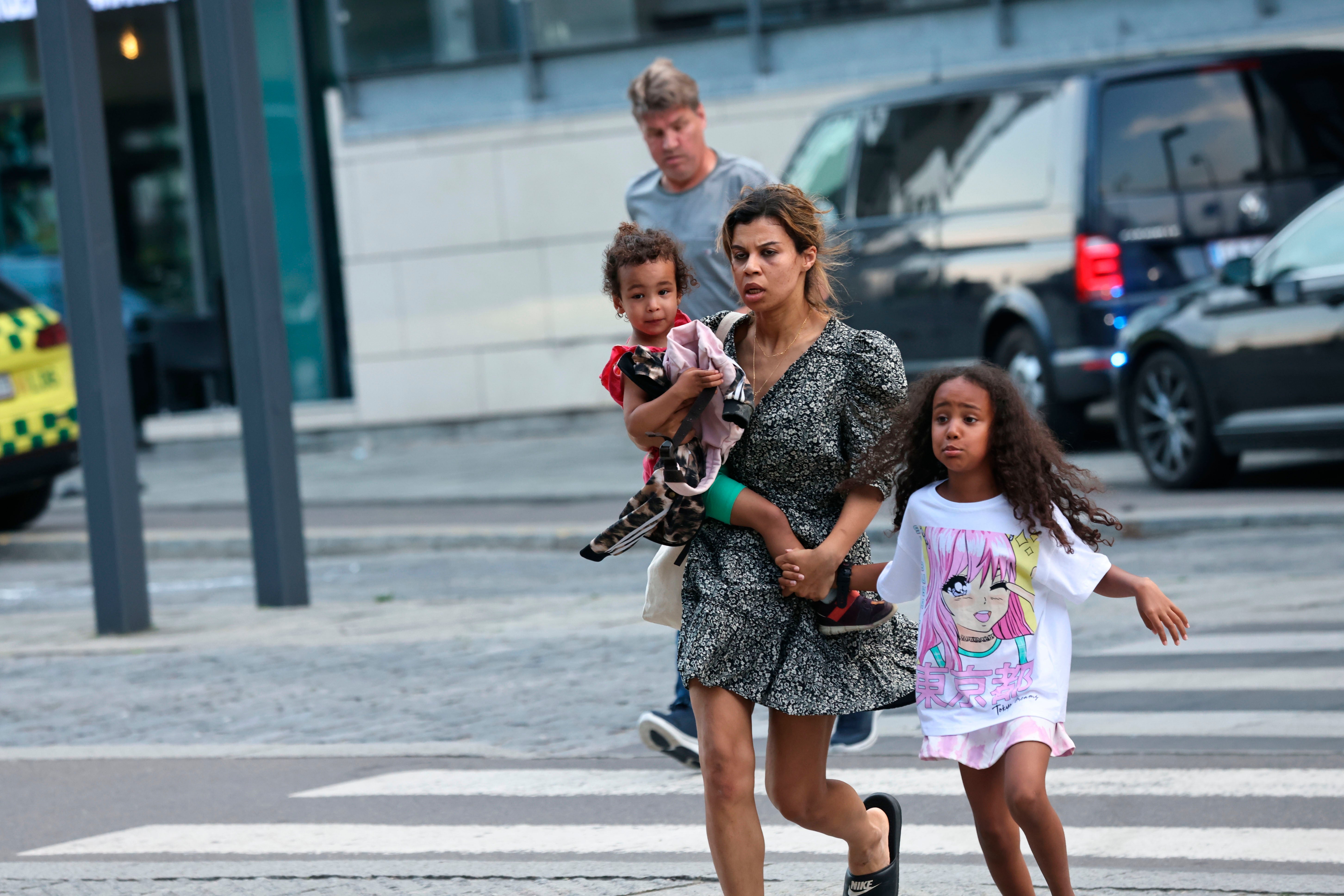 Una mujer y niños huyen del centro comercial Field (Olafur Steinar Gestsson/Ritzau Scanpix via AP)
