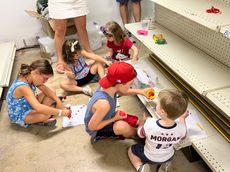 Foto desgarradora muestra a niños colorear en piso de tienda mientras se esconden del tirador en Highland Park
