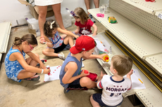 Foto desgarradora muestra a niños colorear en piso de tienda mientras se esconden del tirador en Highland Park