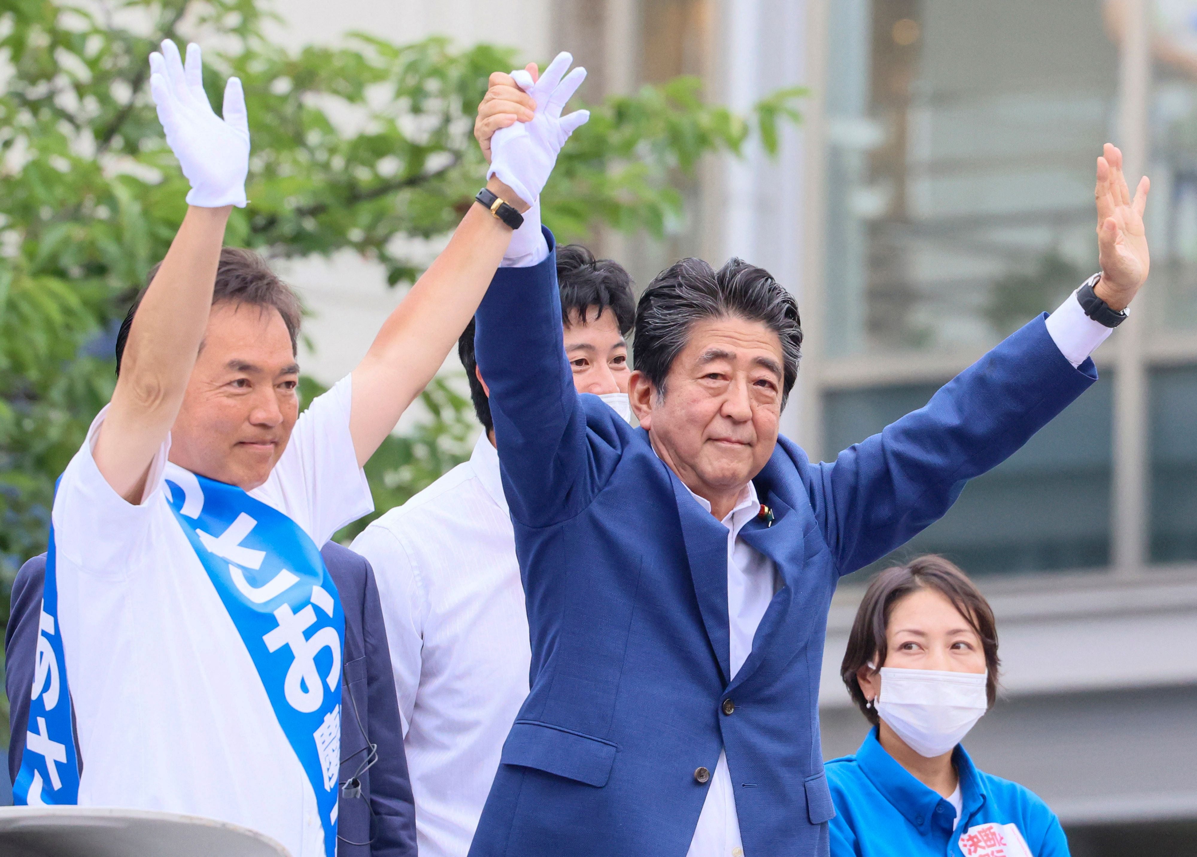 El exprimer ministro japonés Shinzo Abe animando en un acto el miércoles con el candidato del Partido Liberal Democrático Keiichiro Asao