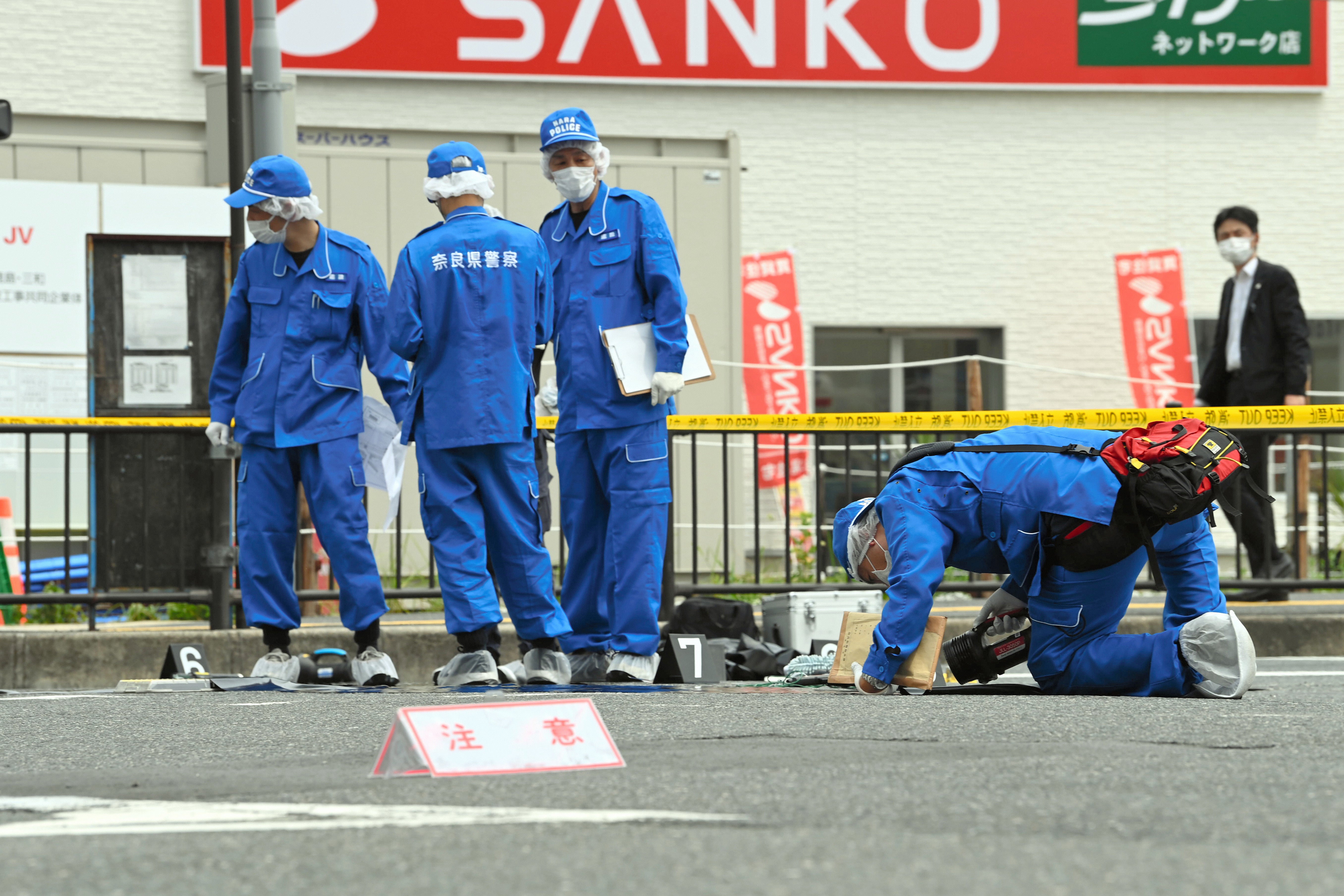 Los agentes investigan el lugar donde el exprimer ministro Shinzo Abe recibió un disparo mientras pronunciaba un discurso frente a la estación de Yamatosaidaiji el 8 de julio en Nara, Japón