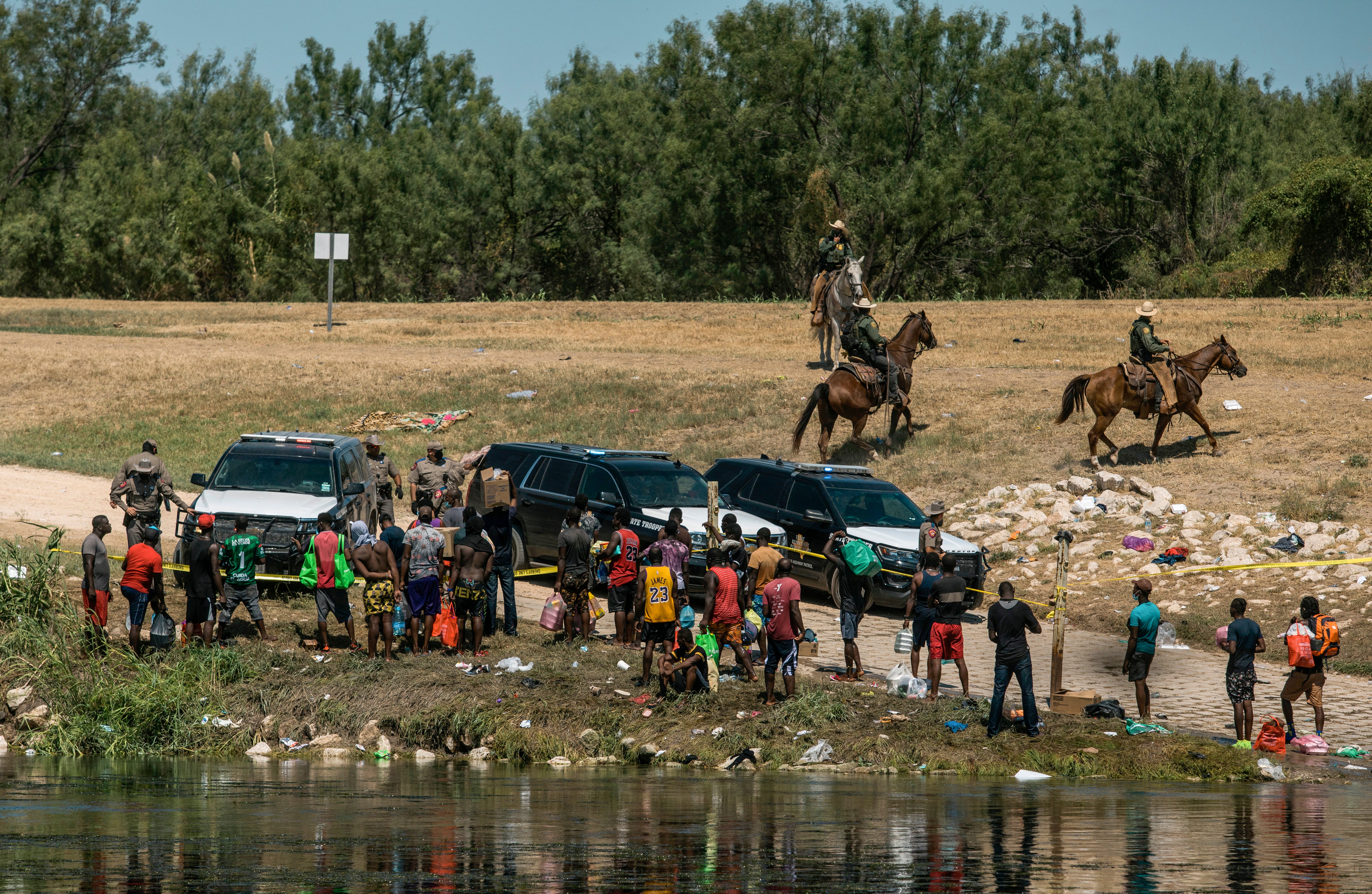Agentes de la patrulla fronteriza de EE.UU. contienen a un grupo de migrantes en la orilla del Río Grande después de que cruzaran desde México, en Del Río, Texas, 19 de septiembre de 2021