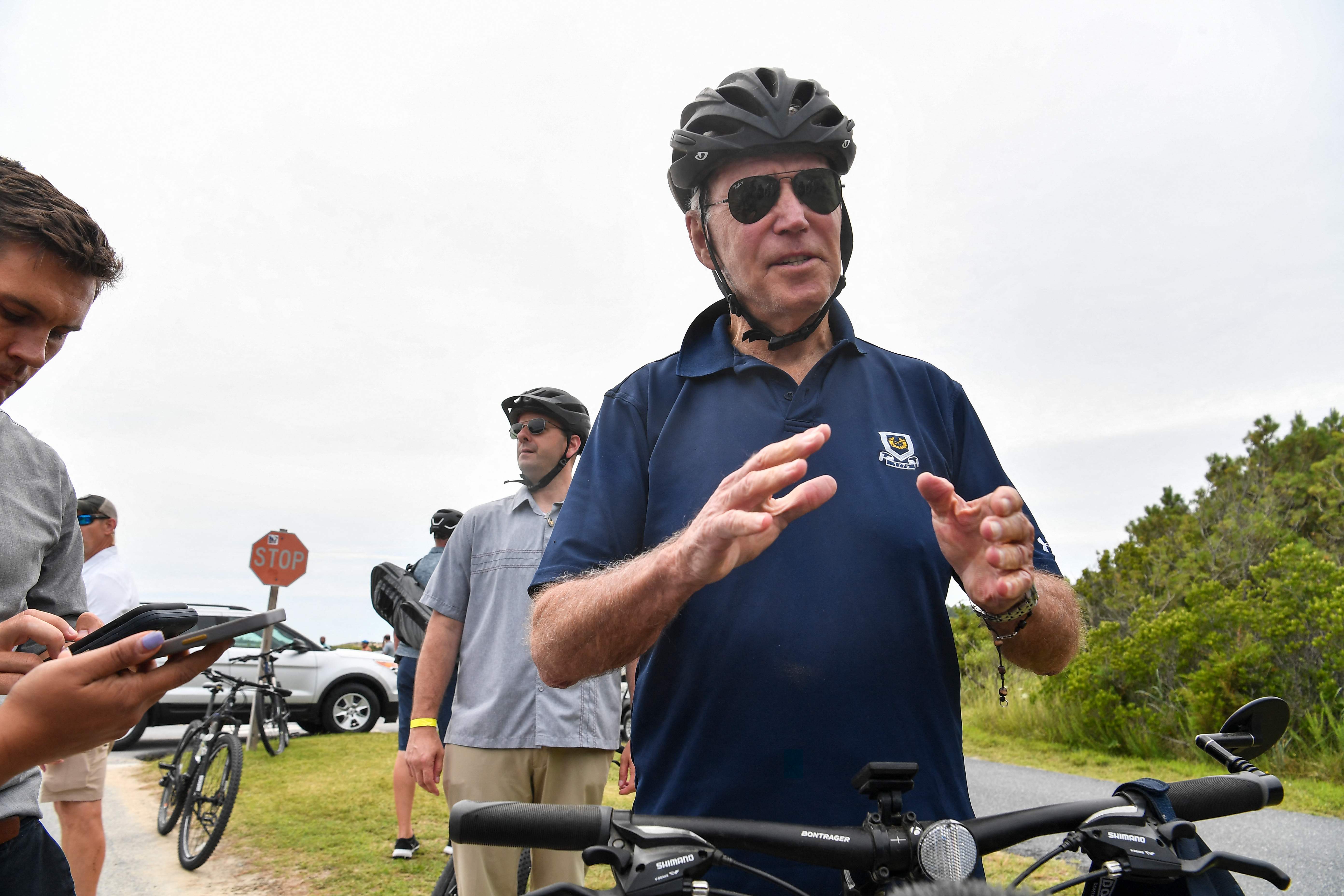 El presidente Joe Biden se detiene a hablar con los periodistas durante un paseo en bicicleta en Rehobeth Beach, Delaware, el 10 de julio