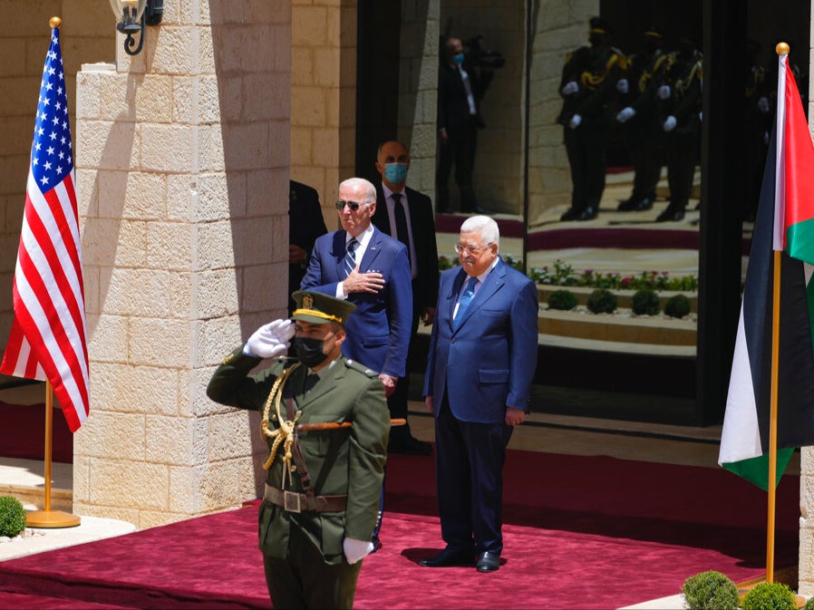Joe Biden y Mahmoud Abbas escuchan el himno nacional durante una ceremonia de bienvenida en Belén