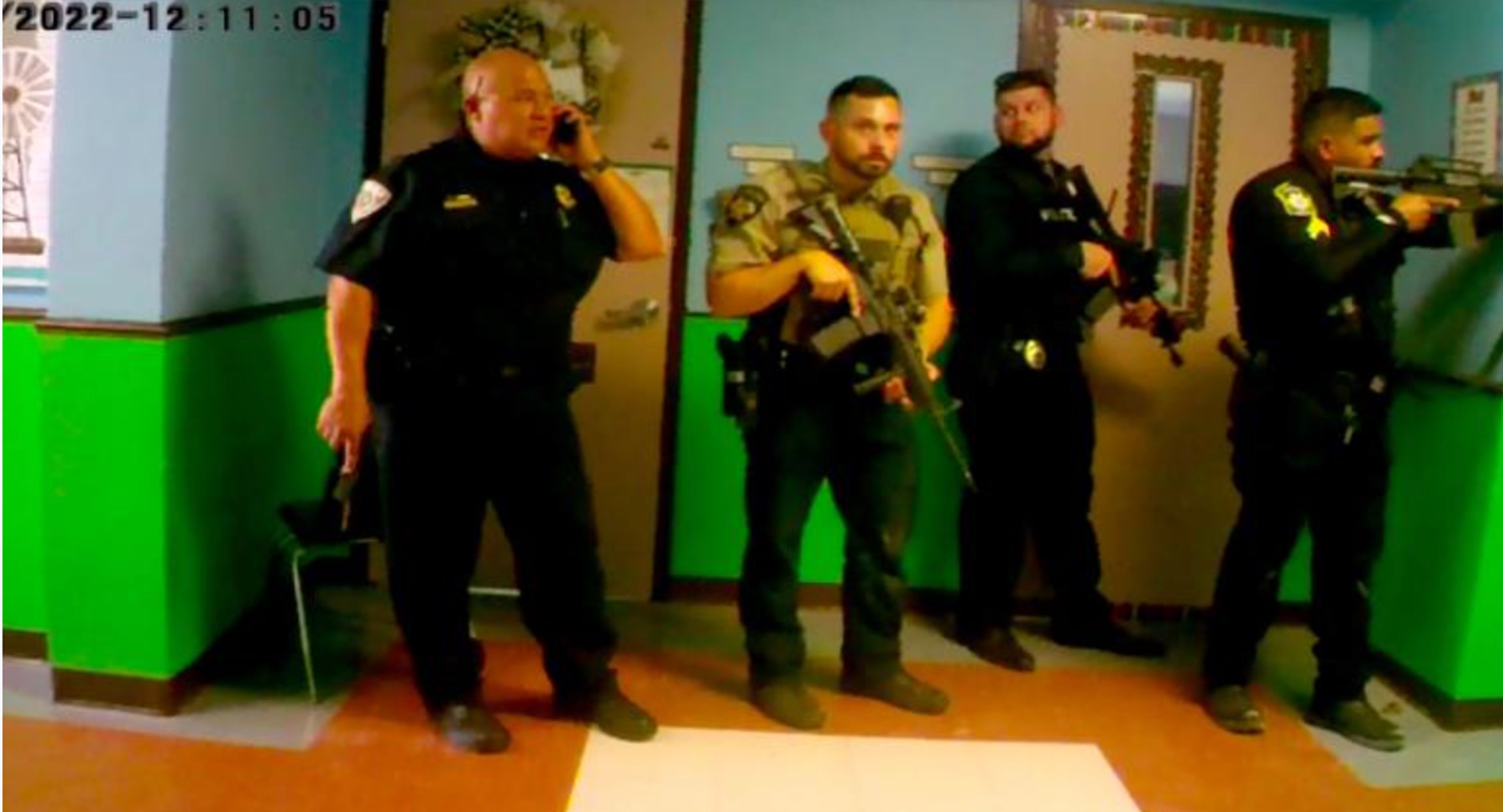 Imágenes de la cámara corporal muestran a oficiales armados y el jefe de la policía escolar, Pete Arredondo, fuera del salón donde se desarrollaba la masacre