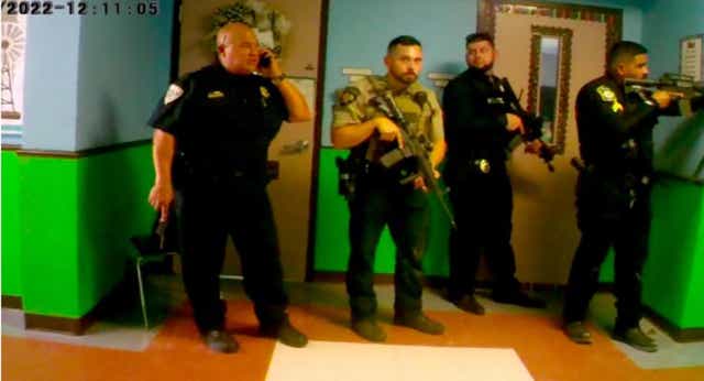 La cámara corporal muestra a agentes armados y al jefe de policía de la Escuela Uvalde, Pete Arredondo, fuera del salón de clases.