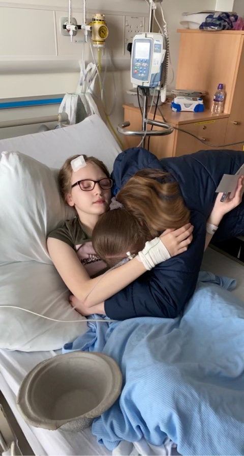 Ava Nelson y su madre en la camilla del hospital