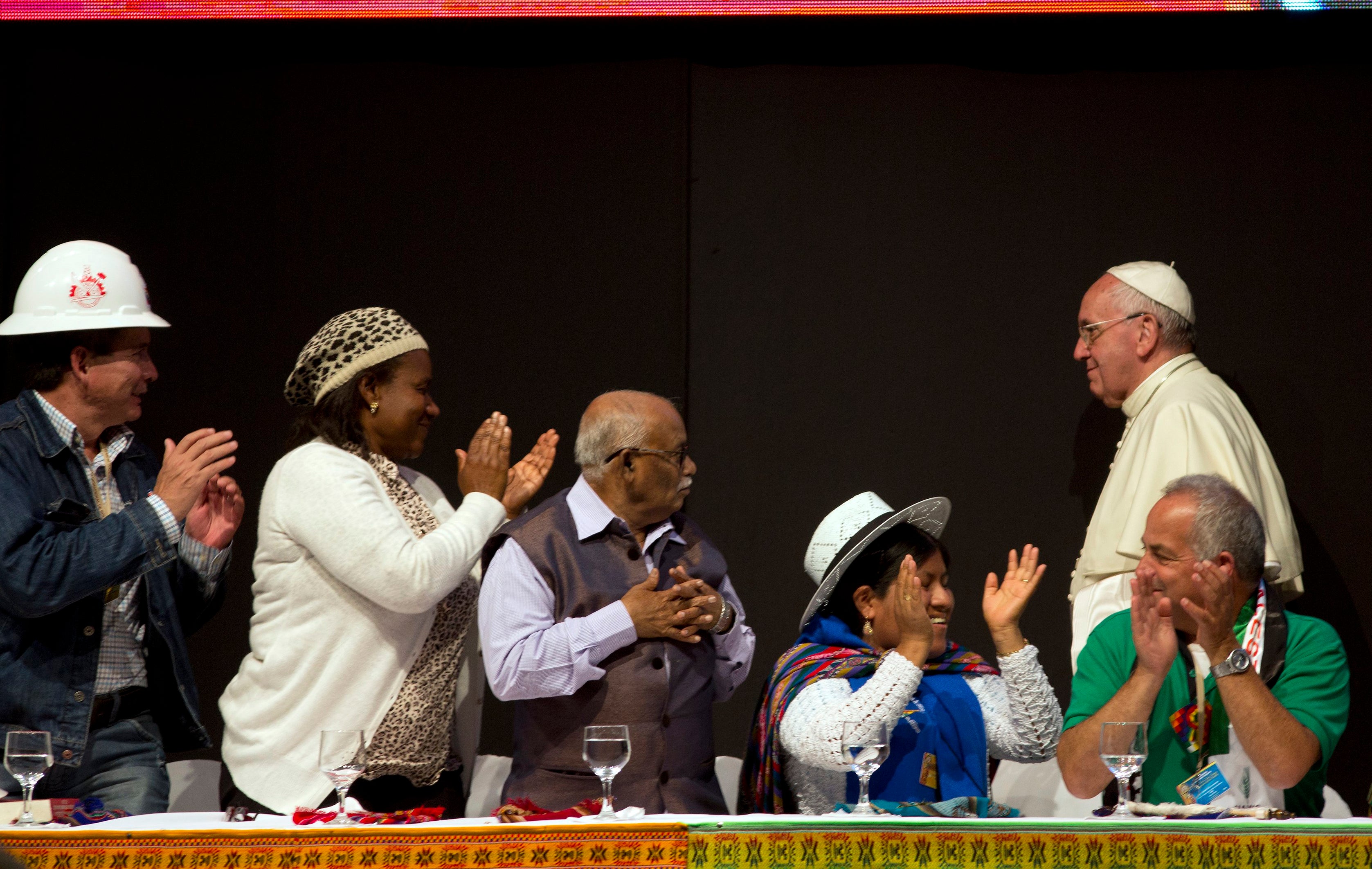 ARCHIVO — Los delegados aplauden al papa Francisco, a la derecha, durante el segundo Encuentro Mundial de Movimientos Populares en Santa Cruz, Bolivia, el jueves 9 de julio de 2015. Durante su visita, Francisco pidió perdón por los agravios cometidos por la iglesia contra los pueblos indígenas durante la conquista de América. (Foto de AP/Rodrigo Abd, Archivo)