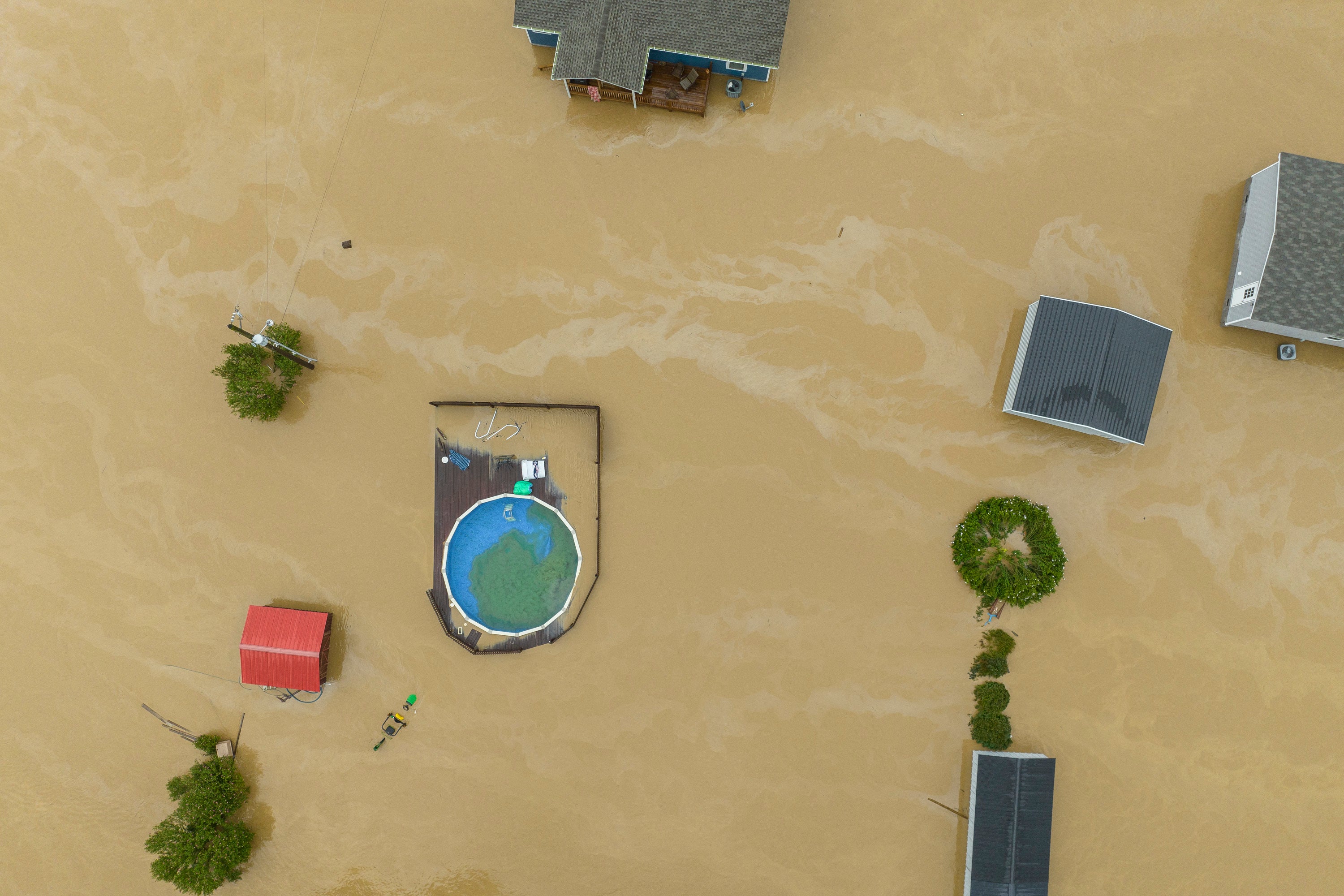 Imagen aérea de un área residencial inundada en Quicksand, Kentucky, mientras las casas son rodeadas por fuertes corrientes
