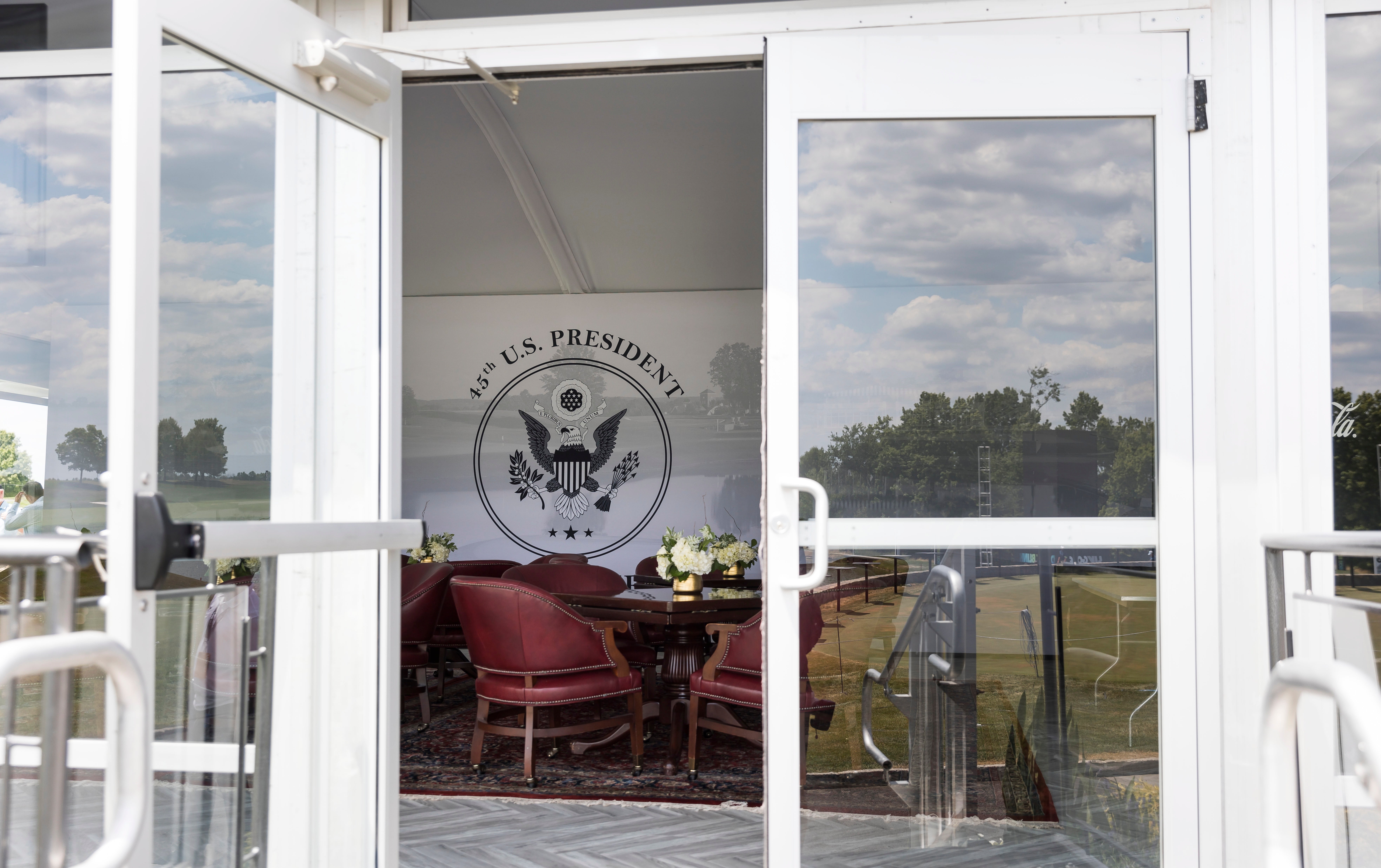 Una sala de observación en una carpa en el green del hoyo 18 con el sello presidencial de EE.UU. en el LIV Golf Bedminster