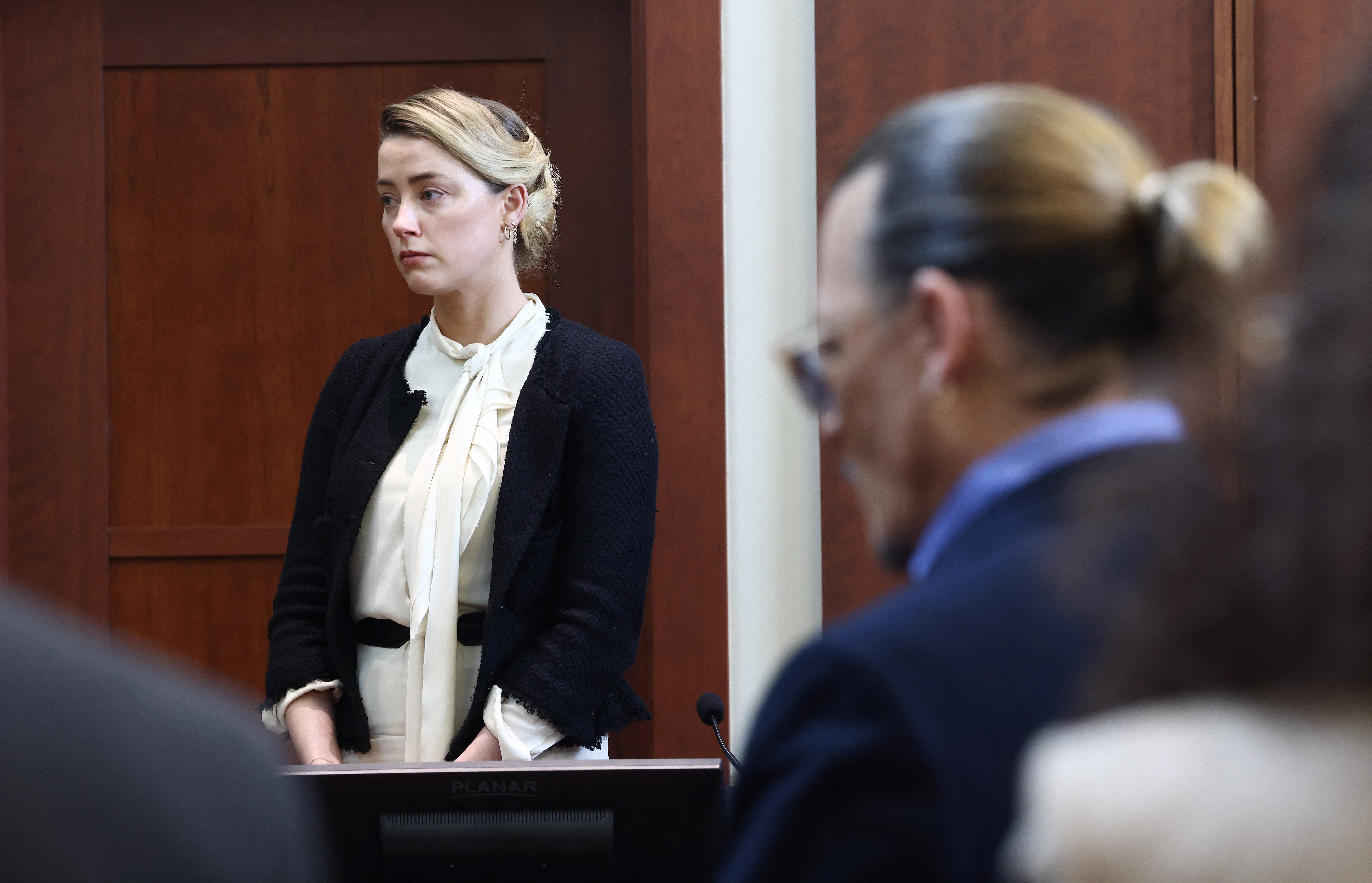 Amber Heard testifica mientras el actor Johnny Depp mira durante su juicio por difamación en mayo de 2022