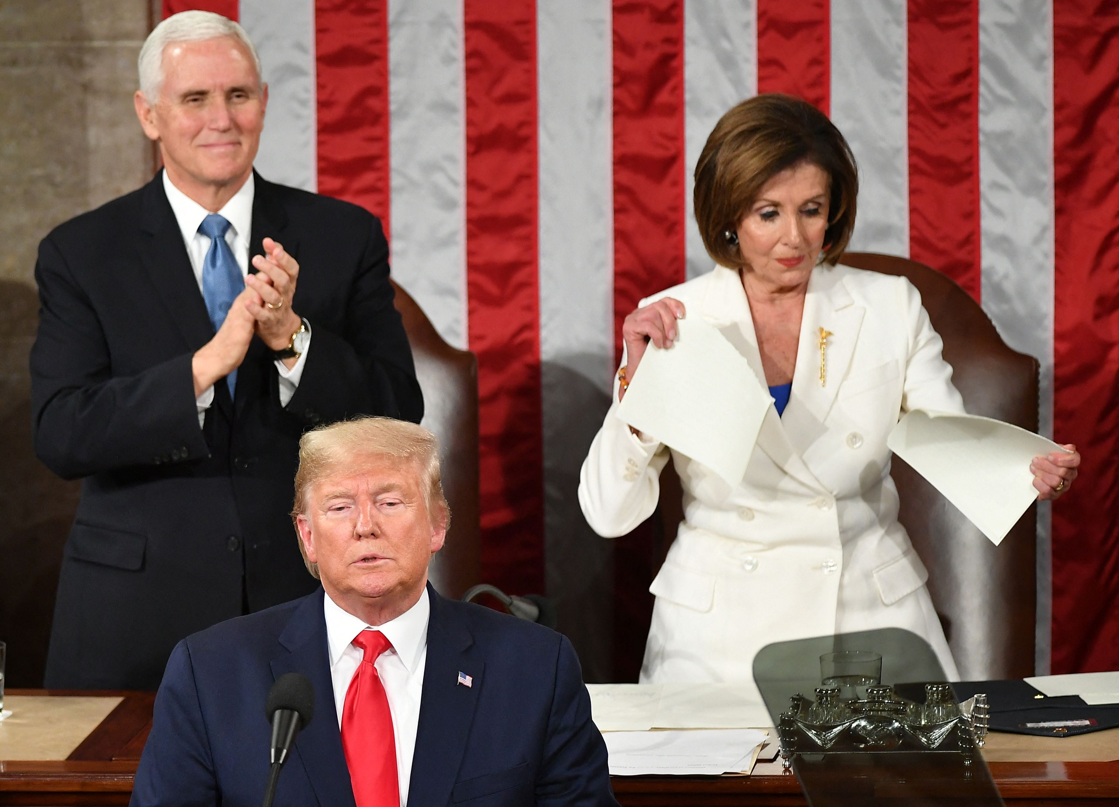 El exvicepresidente Mike Pence aplaude mientras la presidenta la Cámara de Representantes Nancy Pelosi parece romper una copia del discurso del expresidente Donald Trump en el Estado de la Unión en 2020
