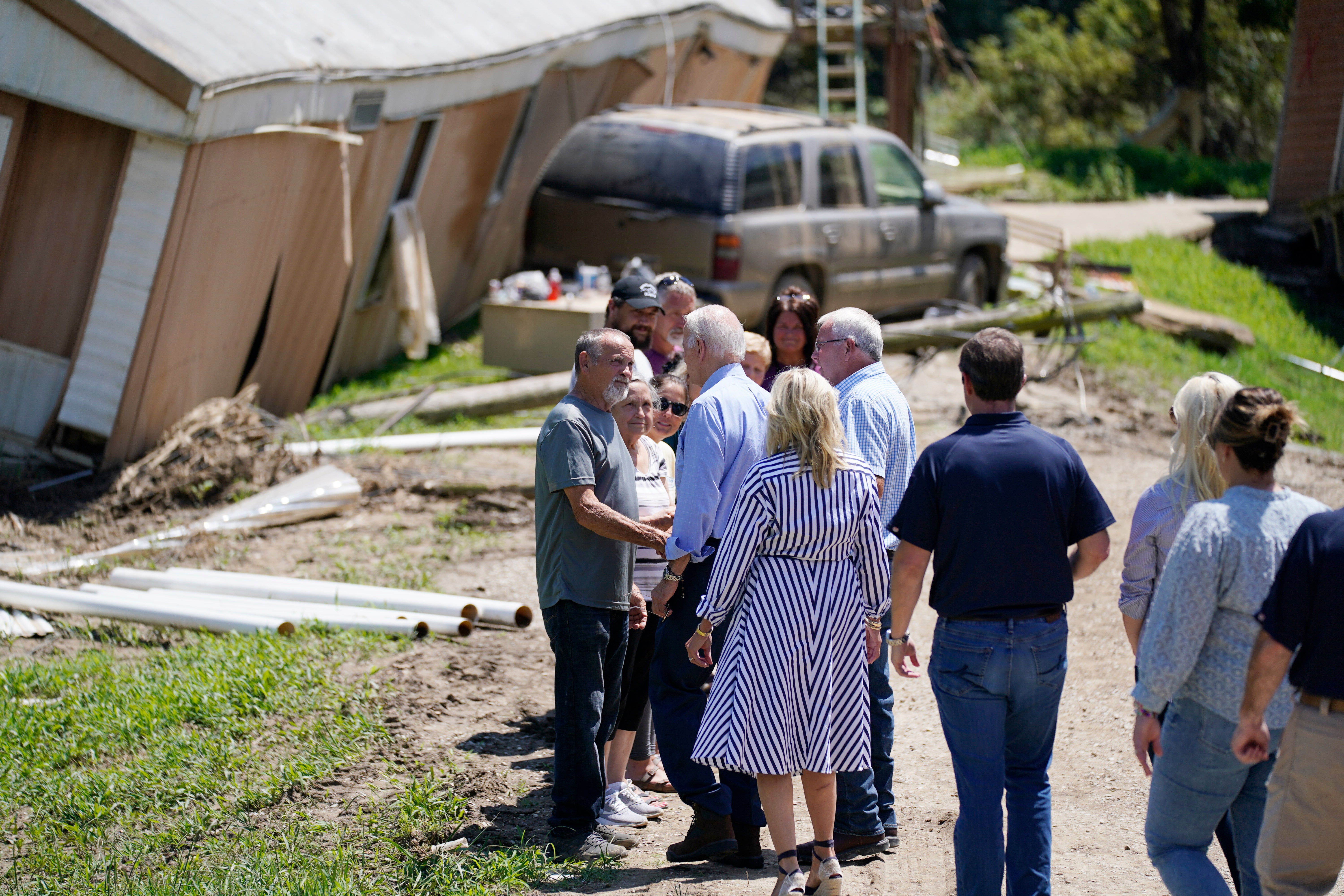 El presidente Joe Biden y la primera dama Jill Biden y otros recorren un barrio afectado por las inundaciones, el lunes 8 de agosto de 2022, en Lost Creek, Kentucky