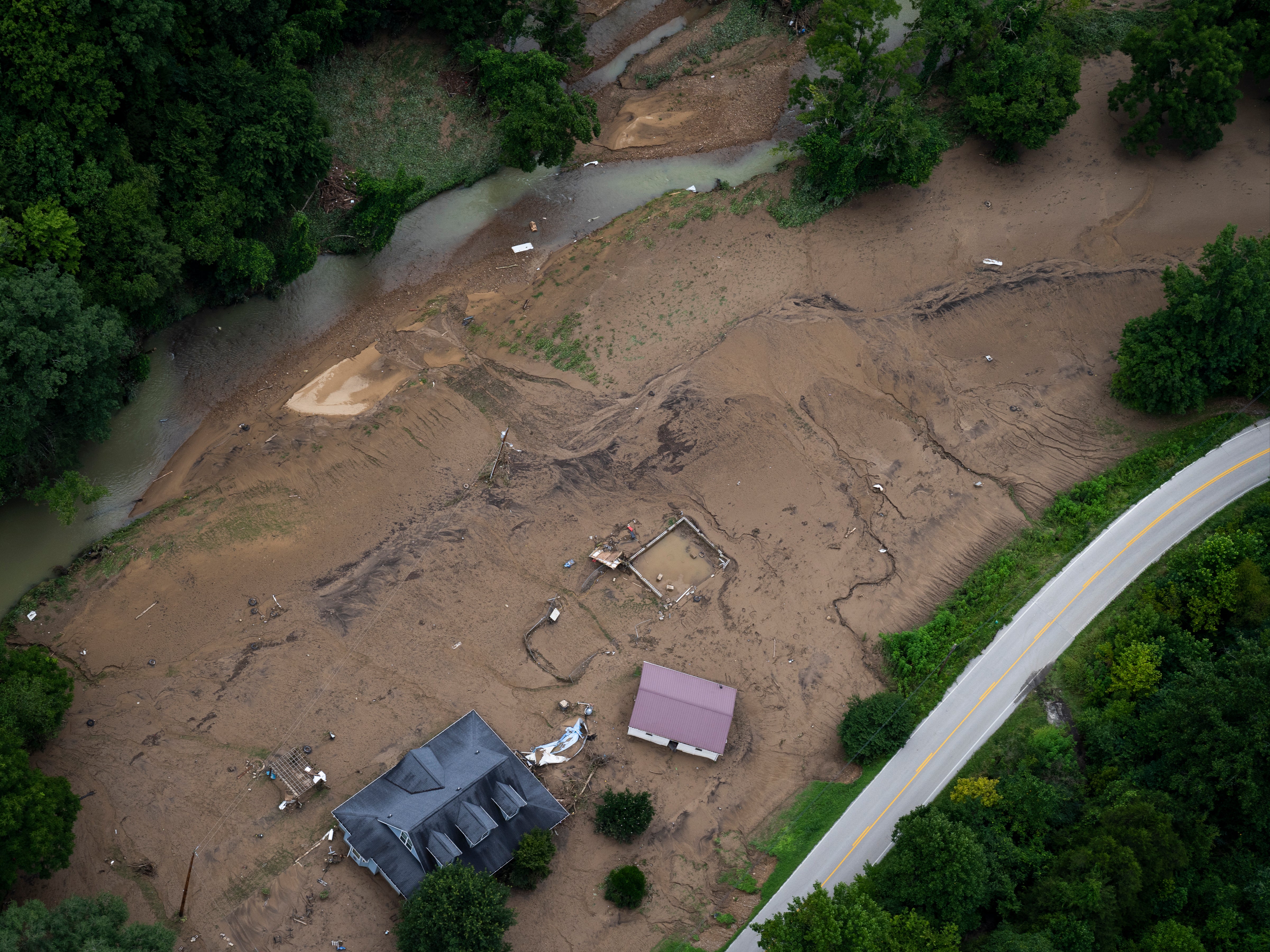 En esta vista aérea, los daños de las inundaciones son visibles mientras la Guardia Nacional de Kentucky vuela en una misión de reconocimiento y rescate el 30 de julio de 2022 en el condado de Breathitt, cerca de Jackson, Kentucky