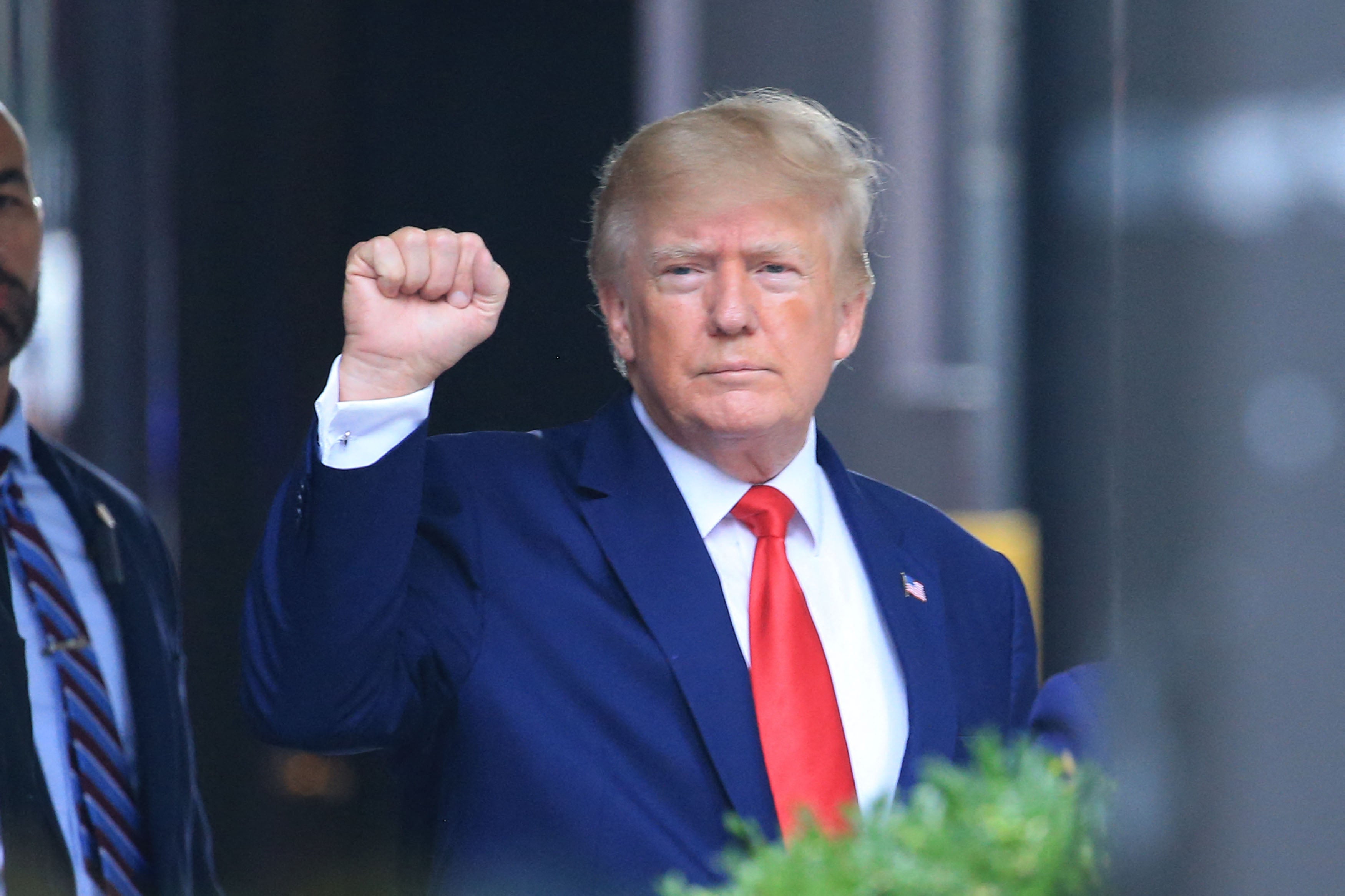 El expresidente de Estados Unidos, Donald Trump, levanta el puño mientras camina hacia un vehículo fuera de la Torre Trump en Nueva York el 10 de agosto de 2022