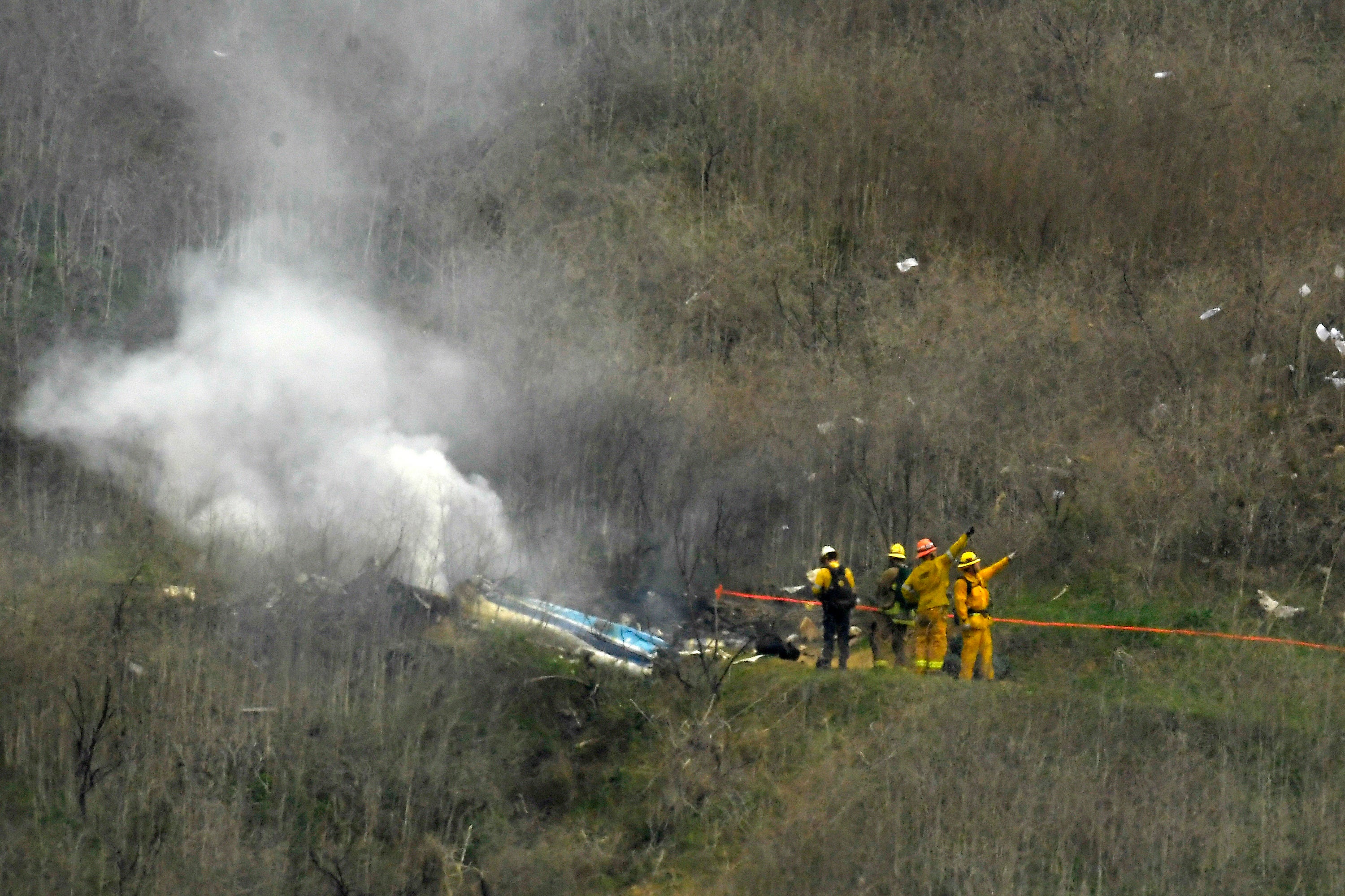 Los bomberos trabajan en el lugar del accidente del helicóptero