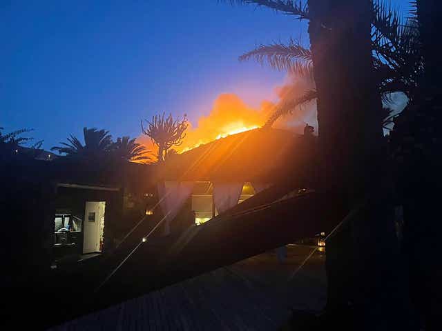 Un incendio forestal arde detrás de la villa del diseñador de moda Giorgio Armani en Pantelleria, una isla frente a la costa de Sicilia.