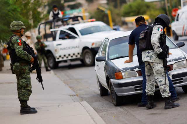 <p>Miembros del Ejército y la Guardia Nacional de México revisan un automóvil en un puesto de control militar, como parte de una operación de seguridad para reducir la violencia, en Ciudad Juárez, México, el 16 de agosto de 2022.</p>