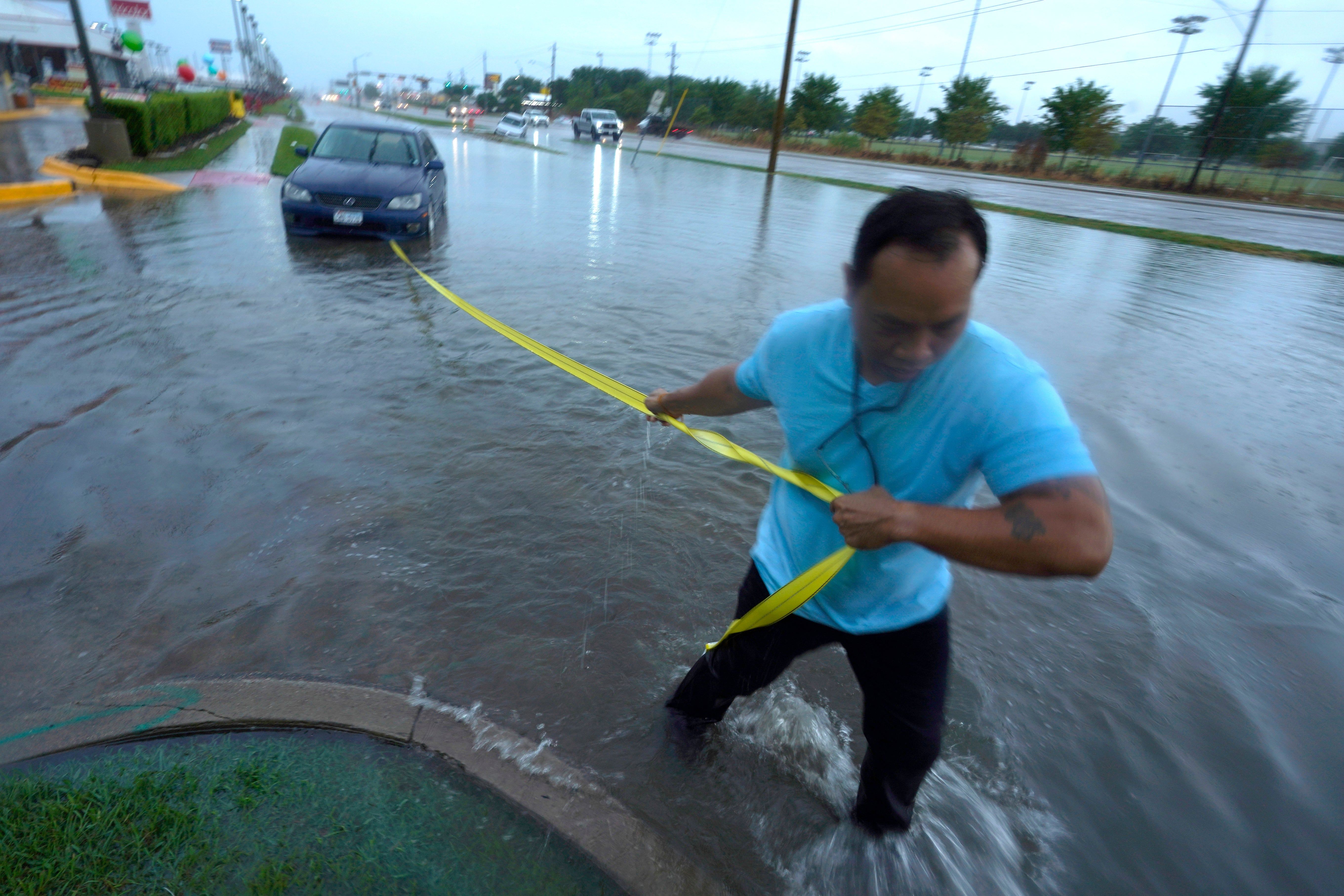 Un hombre saca su automóvil de las aguas de la inundación en Dallas el lunes