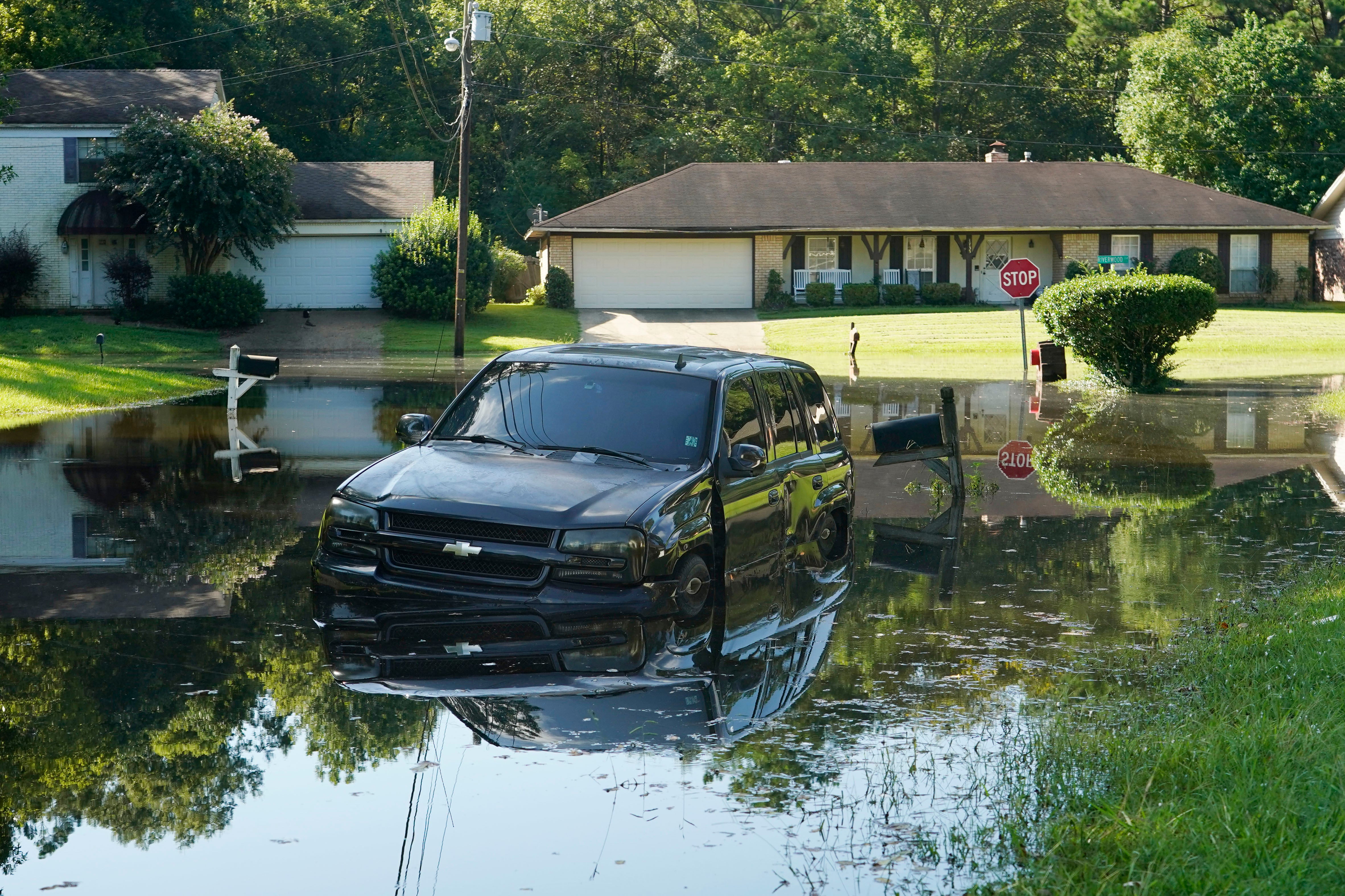 Un auto descansa en las aguas de la inundación en vecindario al noreste de Jackson, Mississippi