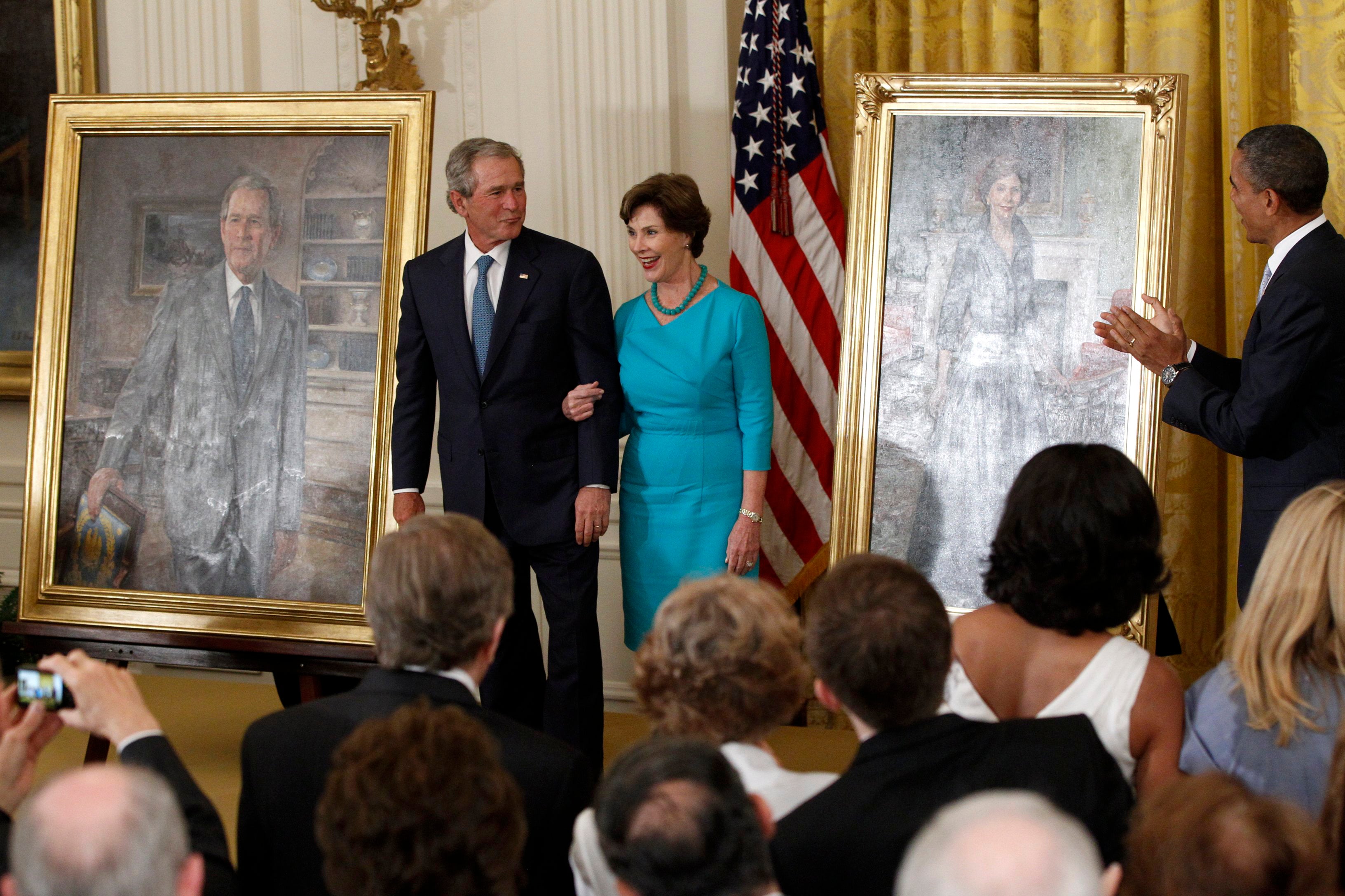 Barack Obama aplaude mientras George W. Bush y su esposa Laura ven sus retratos añadidos a la colección de la Casa Blanca el 31 de mayo de 2012