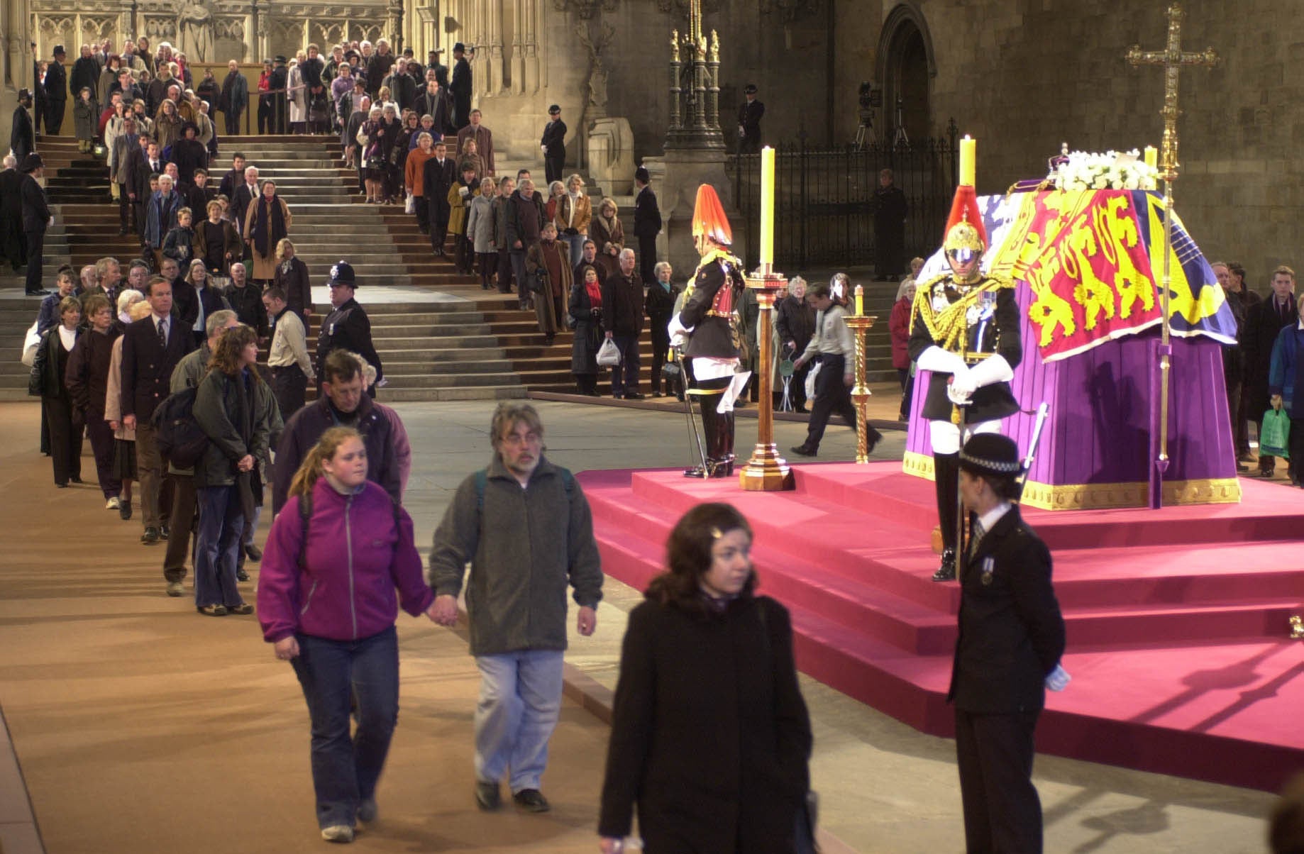 Las personas caminan frente al ataúd de la Reina Madre en el Westminster Hall en 2002 (Stefan Rousseau/PA)