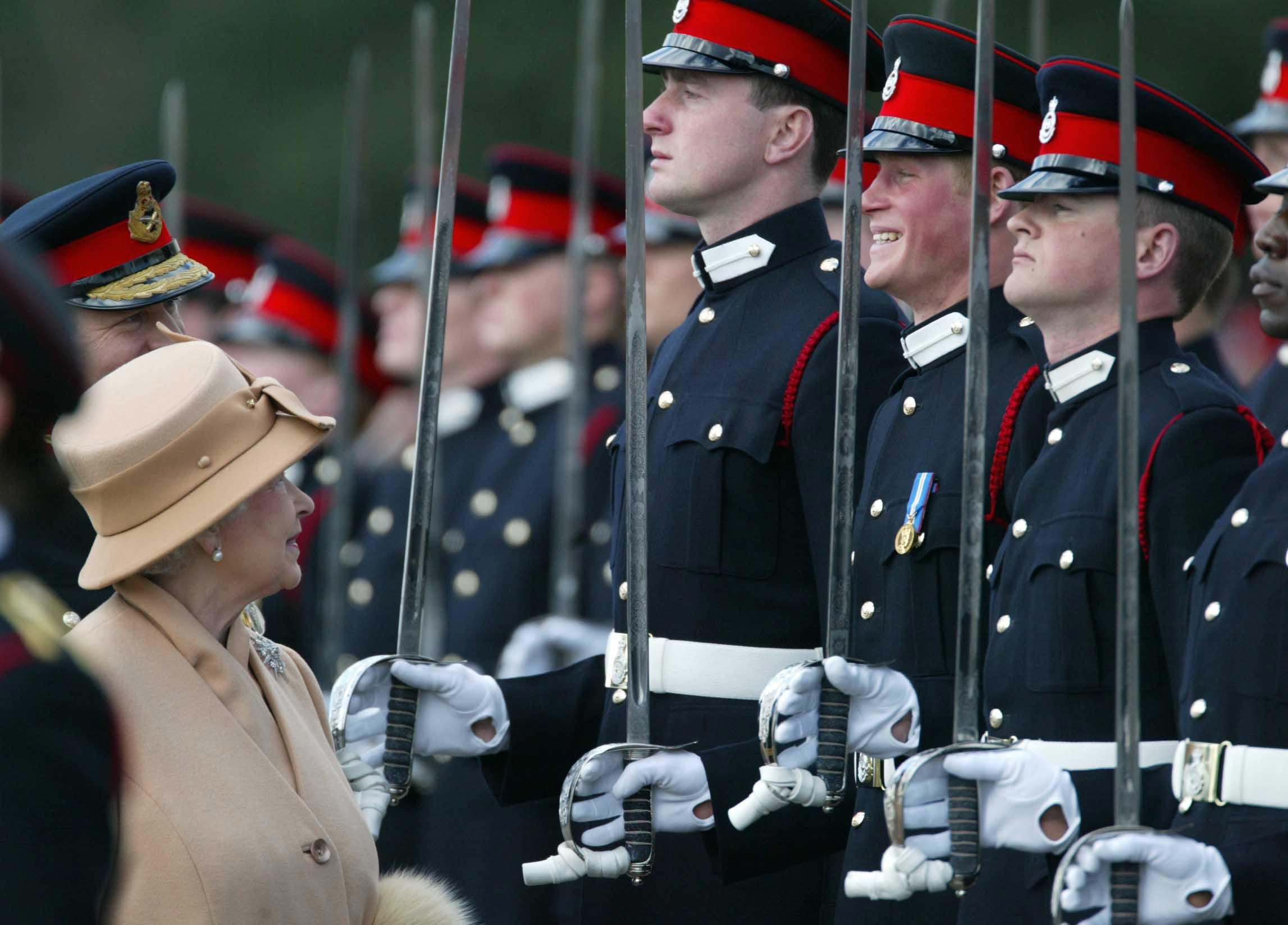 Harry con una. gran sonrisa mientras su abuela la reina Isabel II les pasa revista a él y a otros oficiales durante el Desfile del Soberano en Sandhurst en 2006 (James Vellacott/PA)