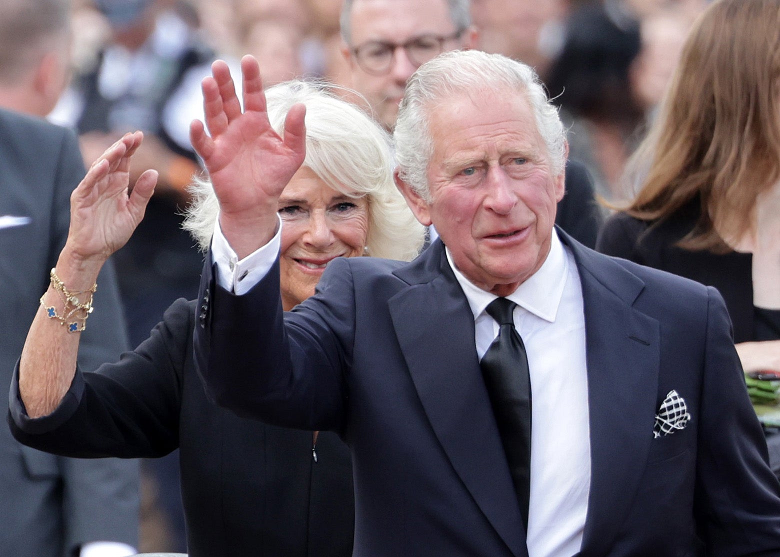 King Charles III and Camilla, Queen Consort wave after viewing floral tributes to the late Queen Elizabeth II outside Buckingham Palace