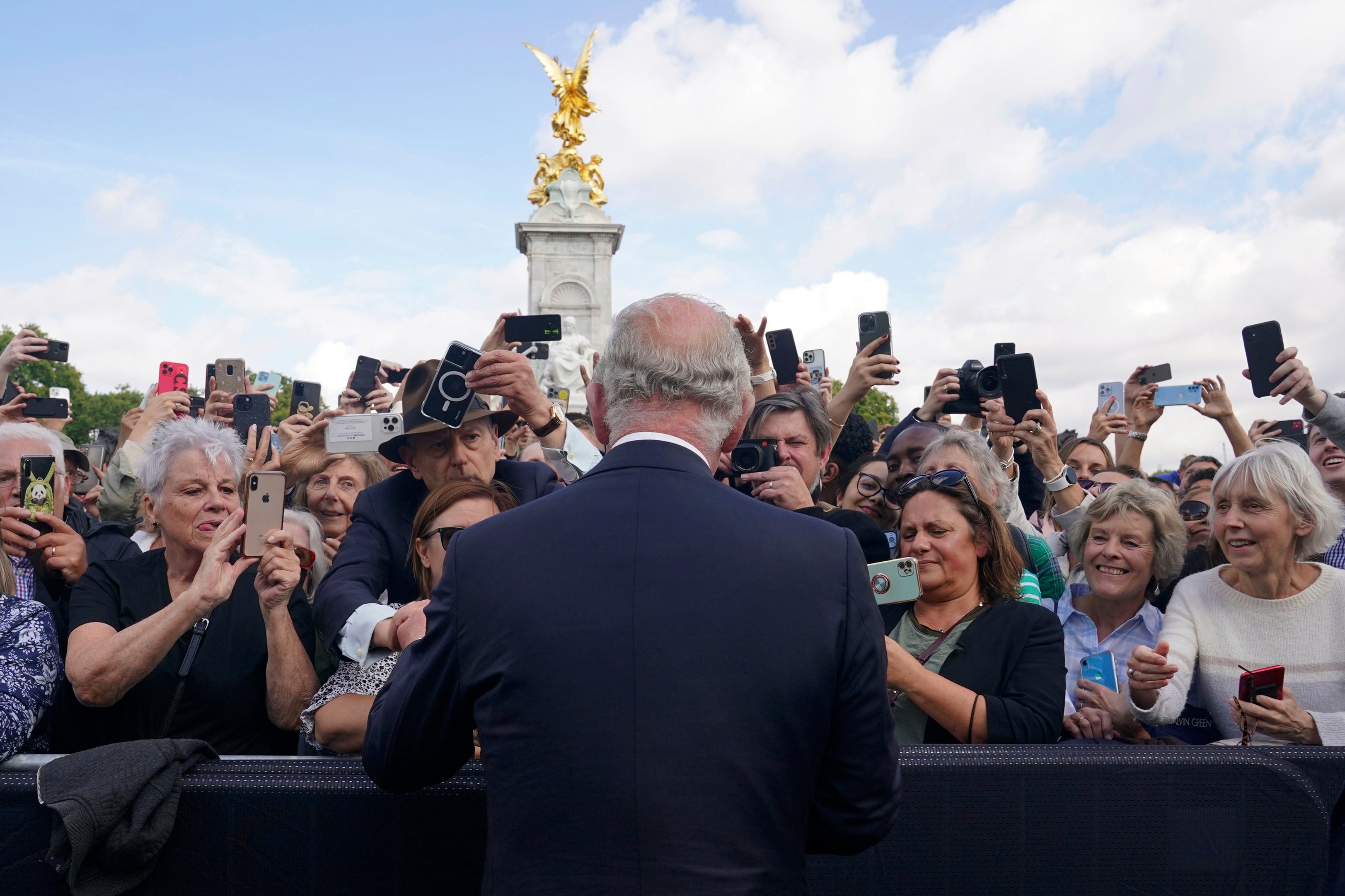 El Rey saluda a los simpatizantes a su paso por las puertas del Palacio de Buckingham el viernes