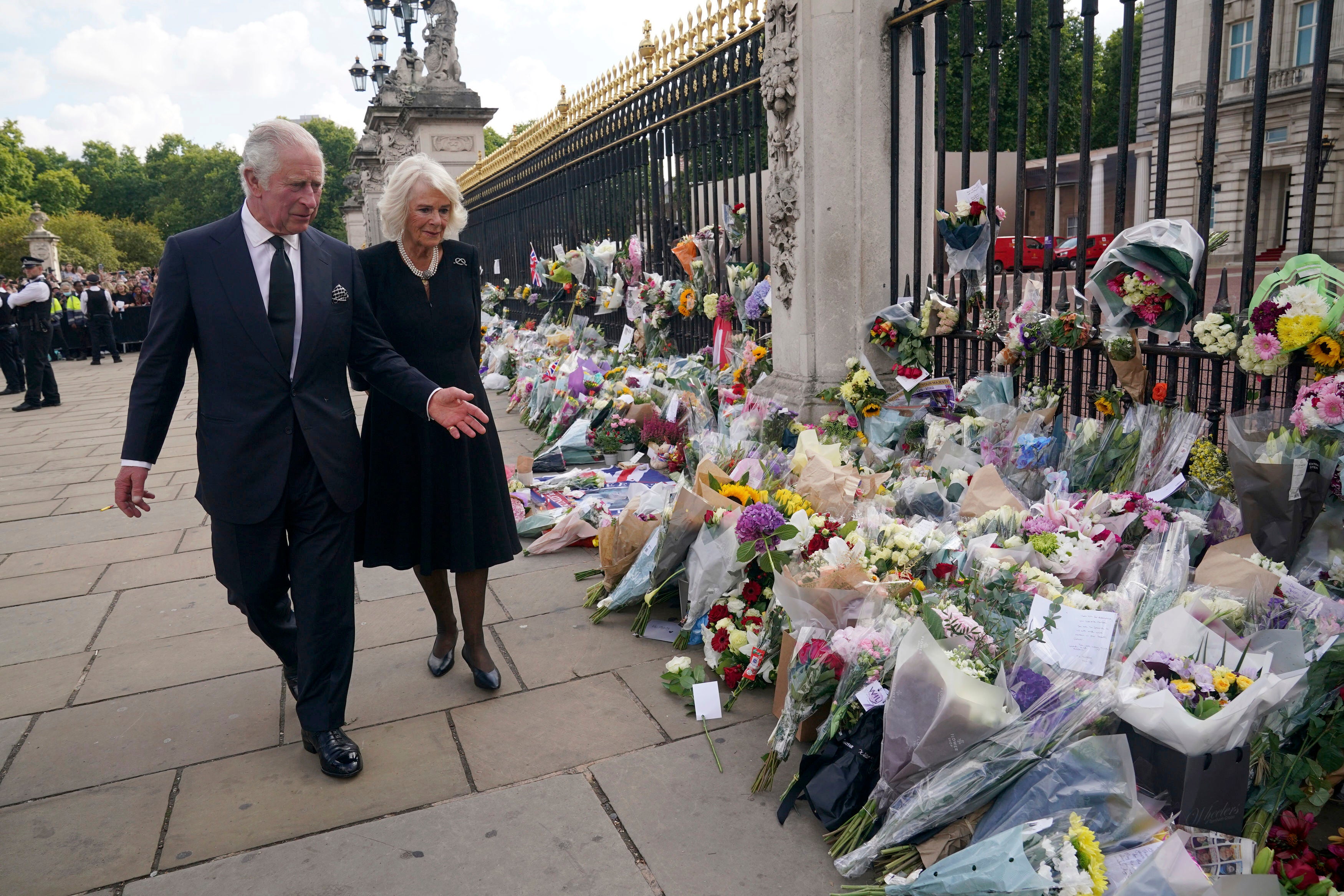 La pareja real observa las ofrendas florales fuera del Palacio de Buckingham el viernes