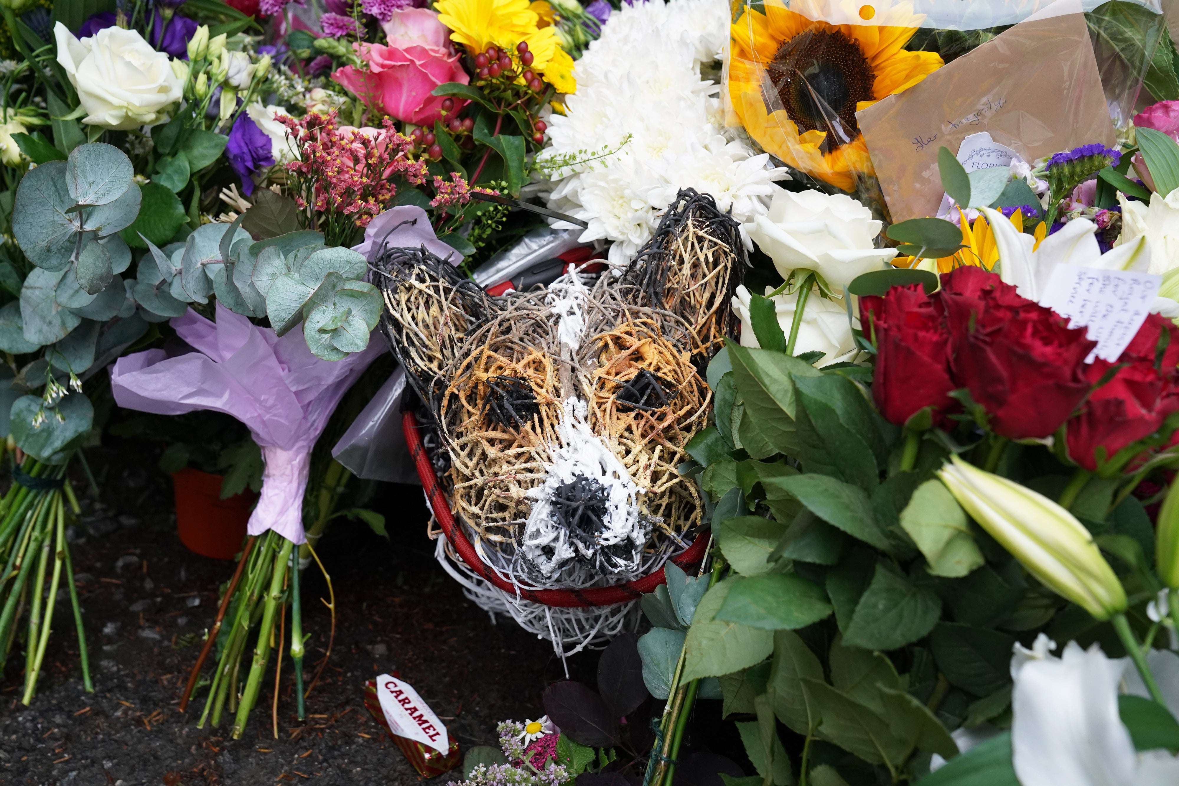 Homenajes florales rodean un modelo de corgi de mimbre que fue dejado a las puertas del Castillo de Balmoral en Aberdeenshire.