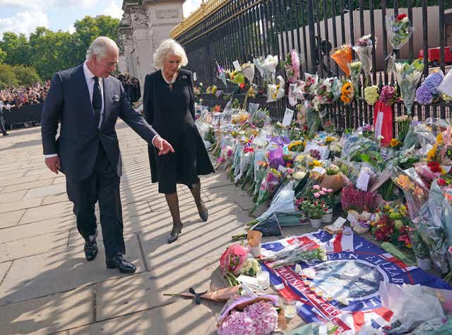 El viernes, el rey Carlos III y la reina vieron los tributos a la reina a la izquierda del Palacio de Buckingham (Yui Mok/PA)