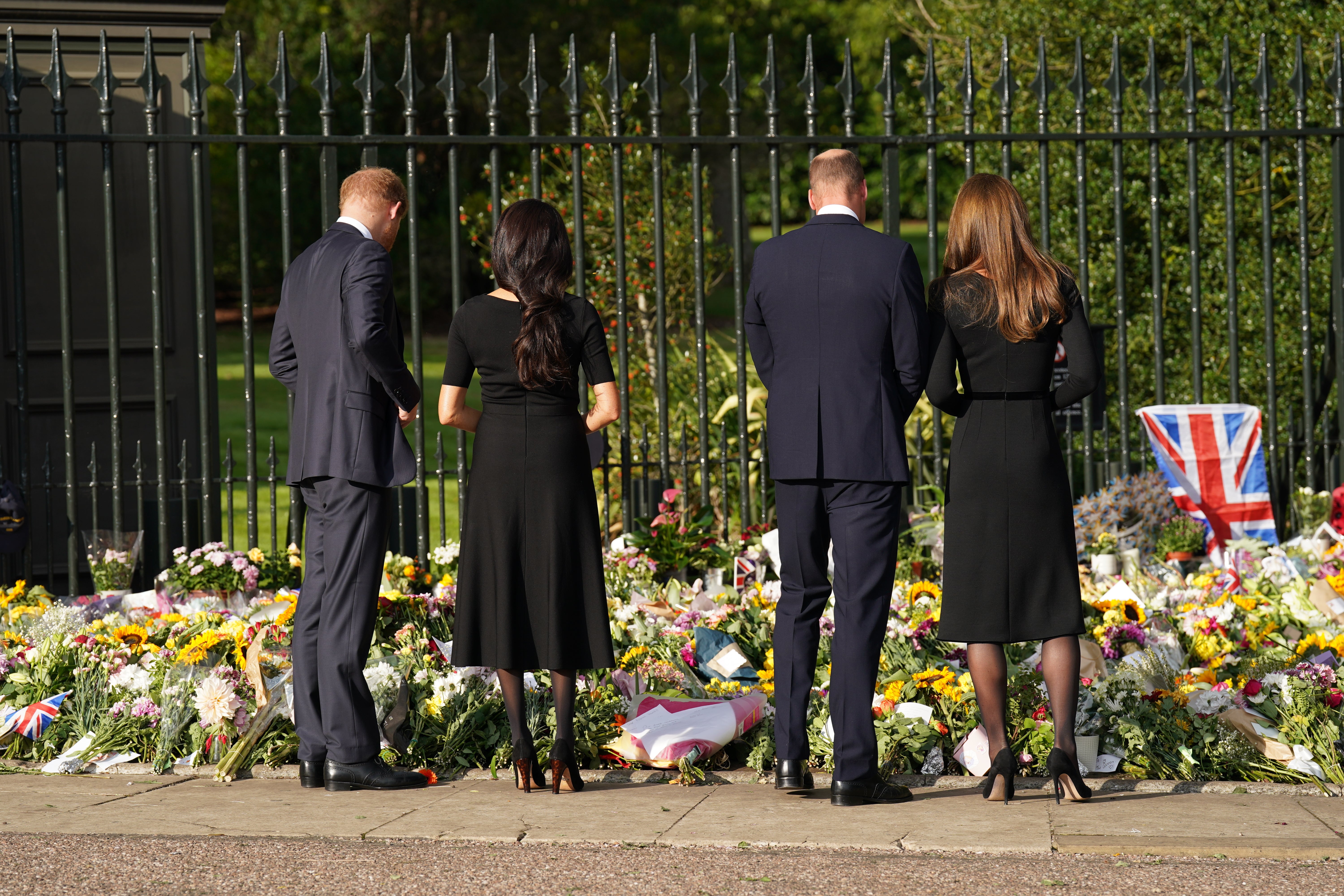 The Duke of Sussex, Duchess of Sussex, Prince of Wales and Princess of Wales view floral tributes left by members of the public at Windsor Castle (Kirsty O’Connor/PA)