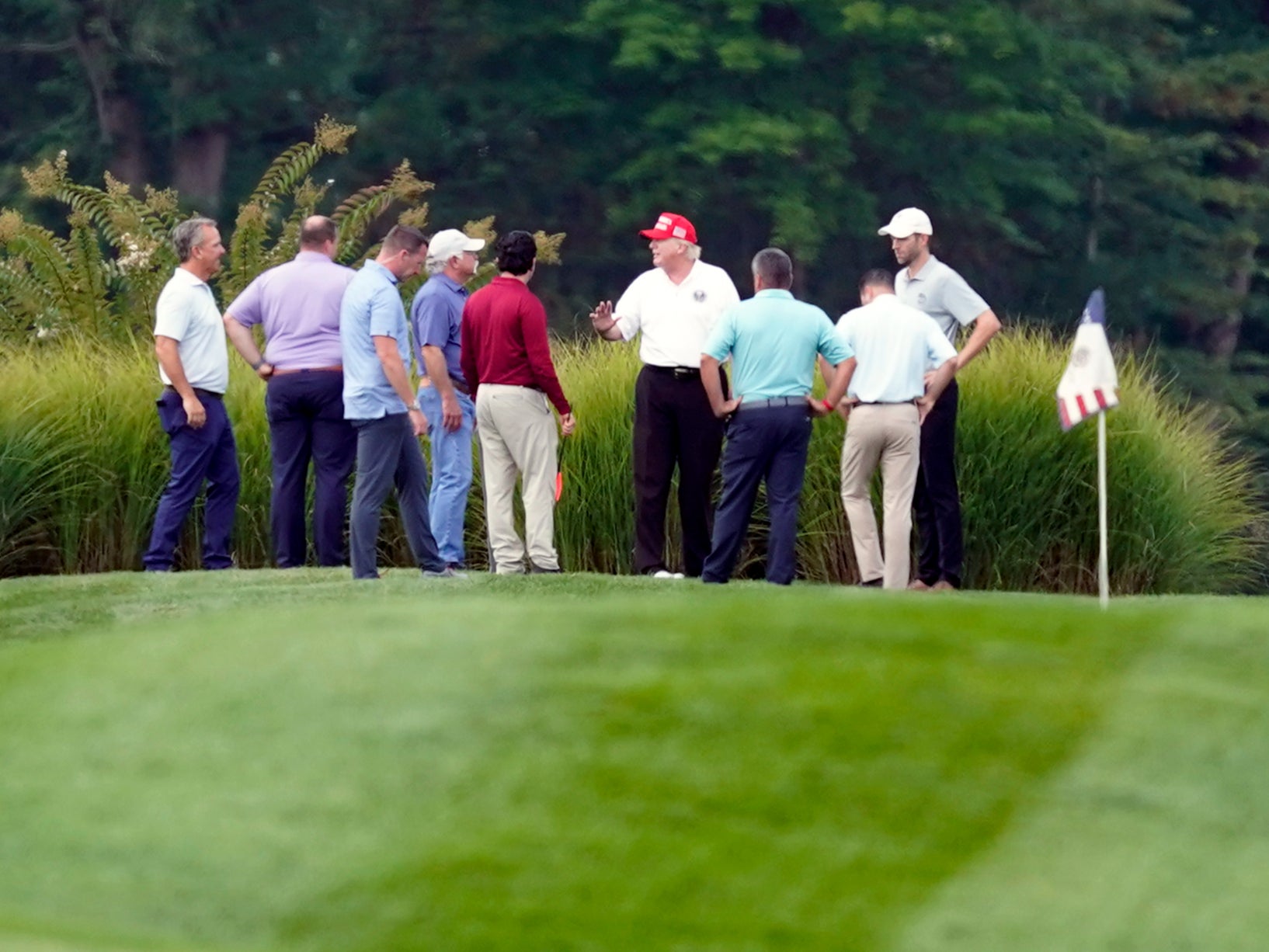 Donald Trump habla con sus asistentes y asesores en el Trump National Golf Club en Sterling, Virginia