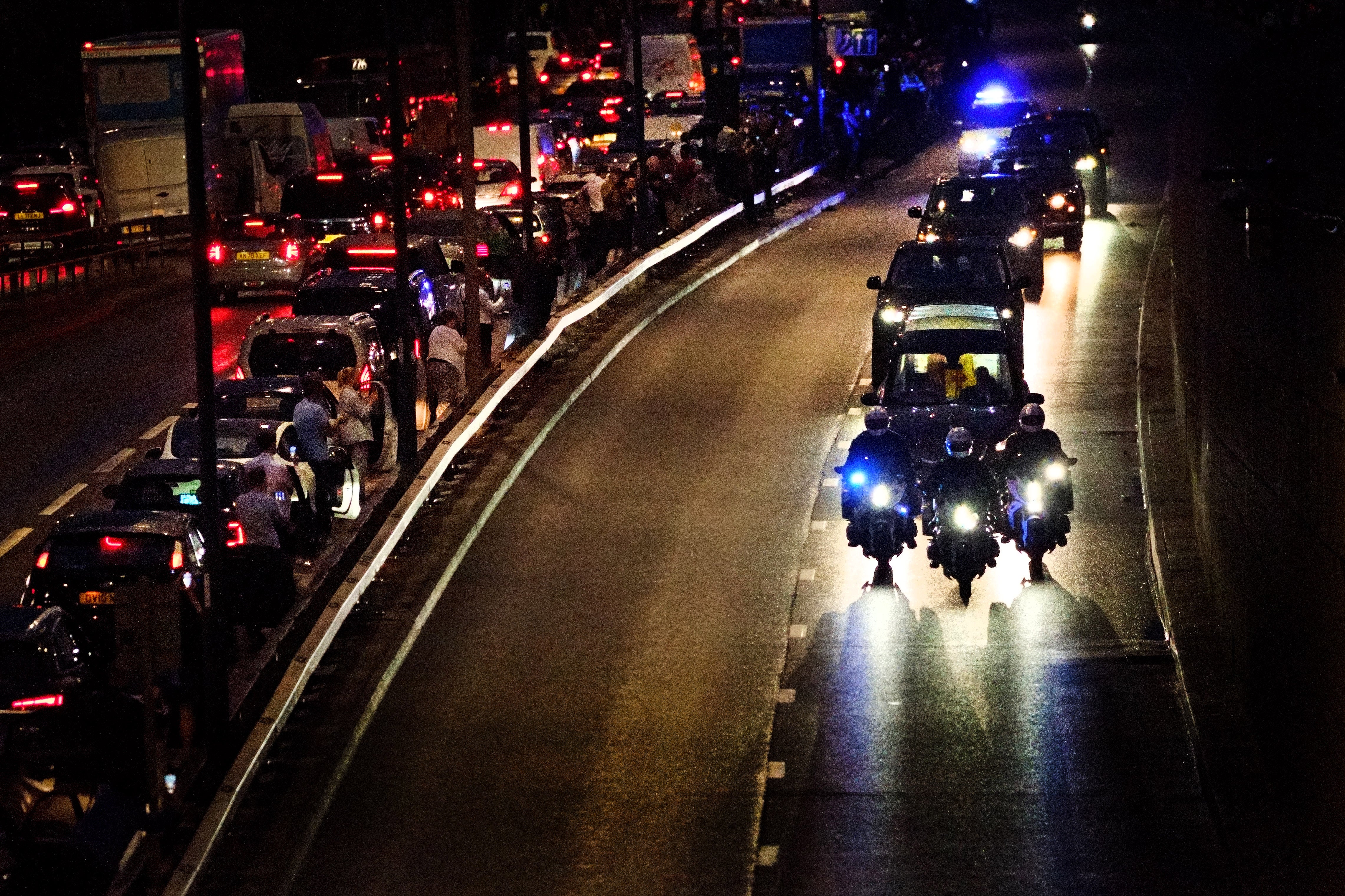 People get out of their cars to watch as the hearse carrying the the Queen’s coffin (Victoria Jones/PA)