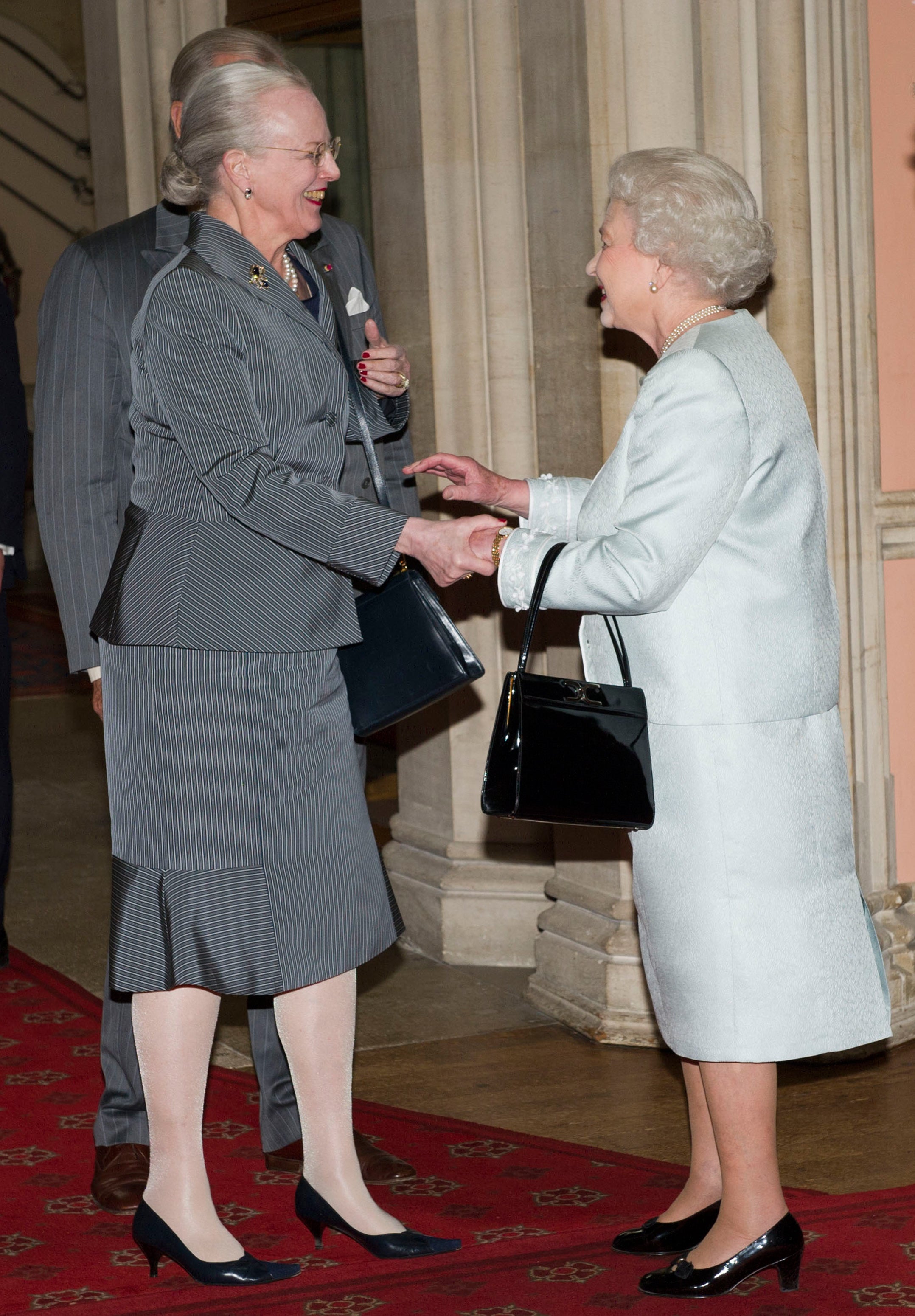 La reina Isabel II derecha da la bienvenida a la reina Margarita II de Dinamarca al Castillo de Windsor, el 18 de mayo de 2012