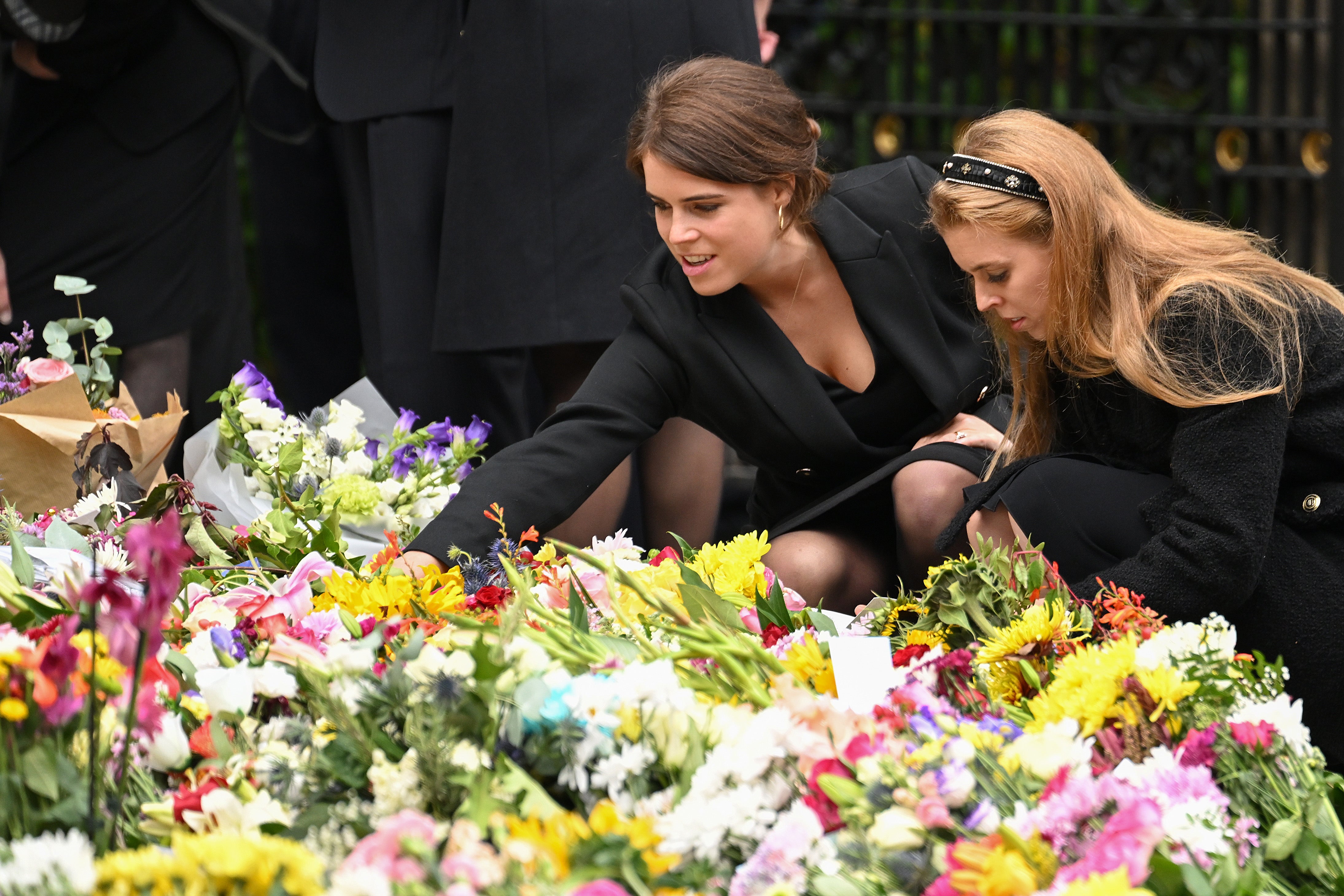Las princesas Eugenie y Beatrice observan las flores que dejaron para la difunta reina Isabel II afuera del castillo Balmoral