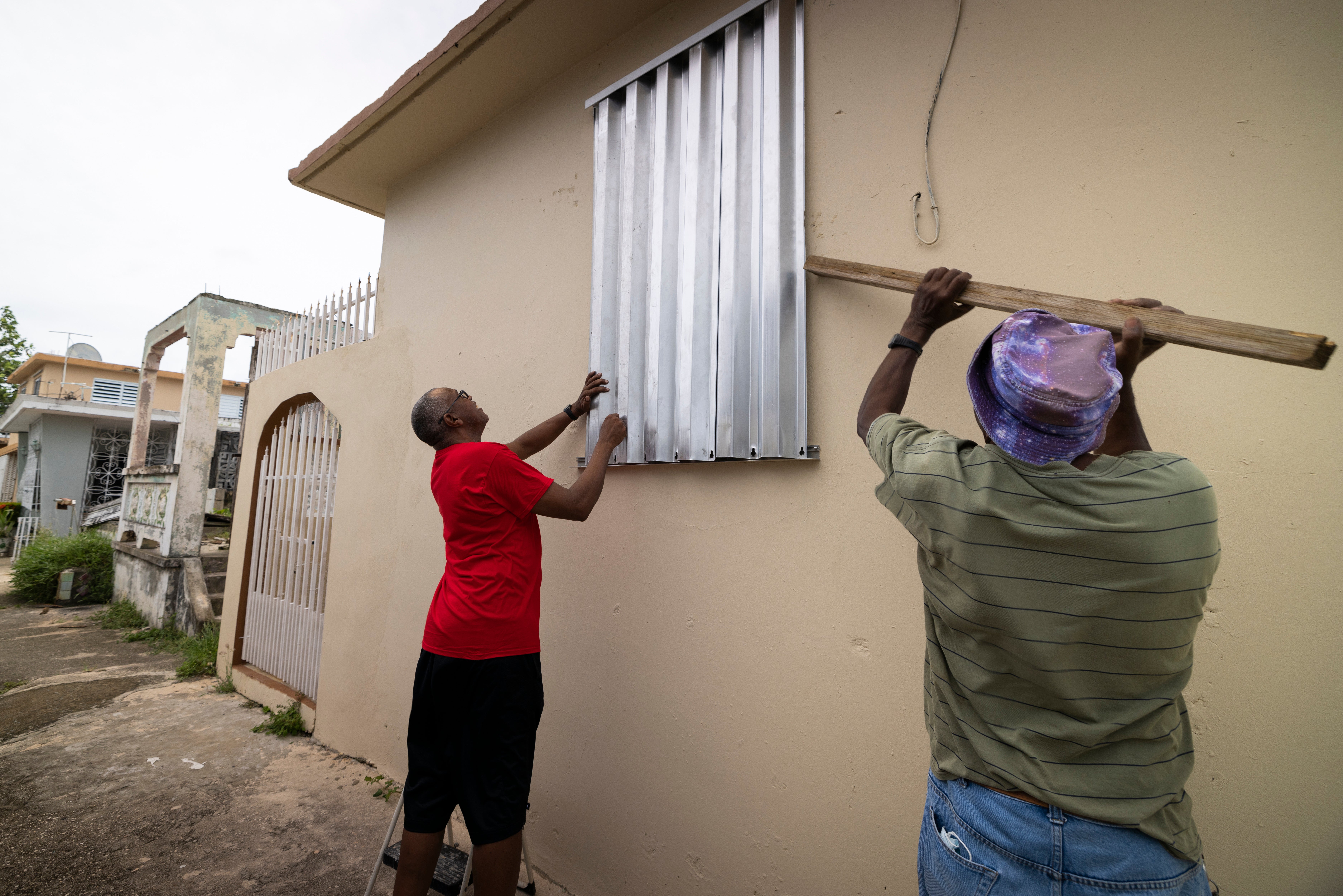 Pobladores protegiendo las ventanas ante la tormenta tropical
