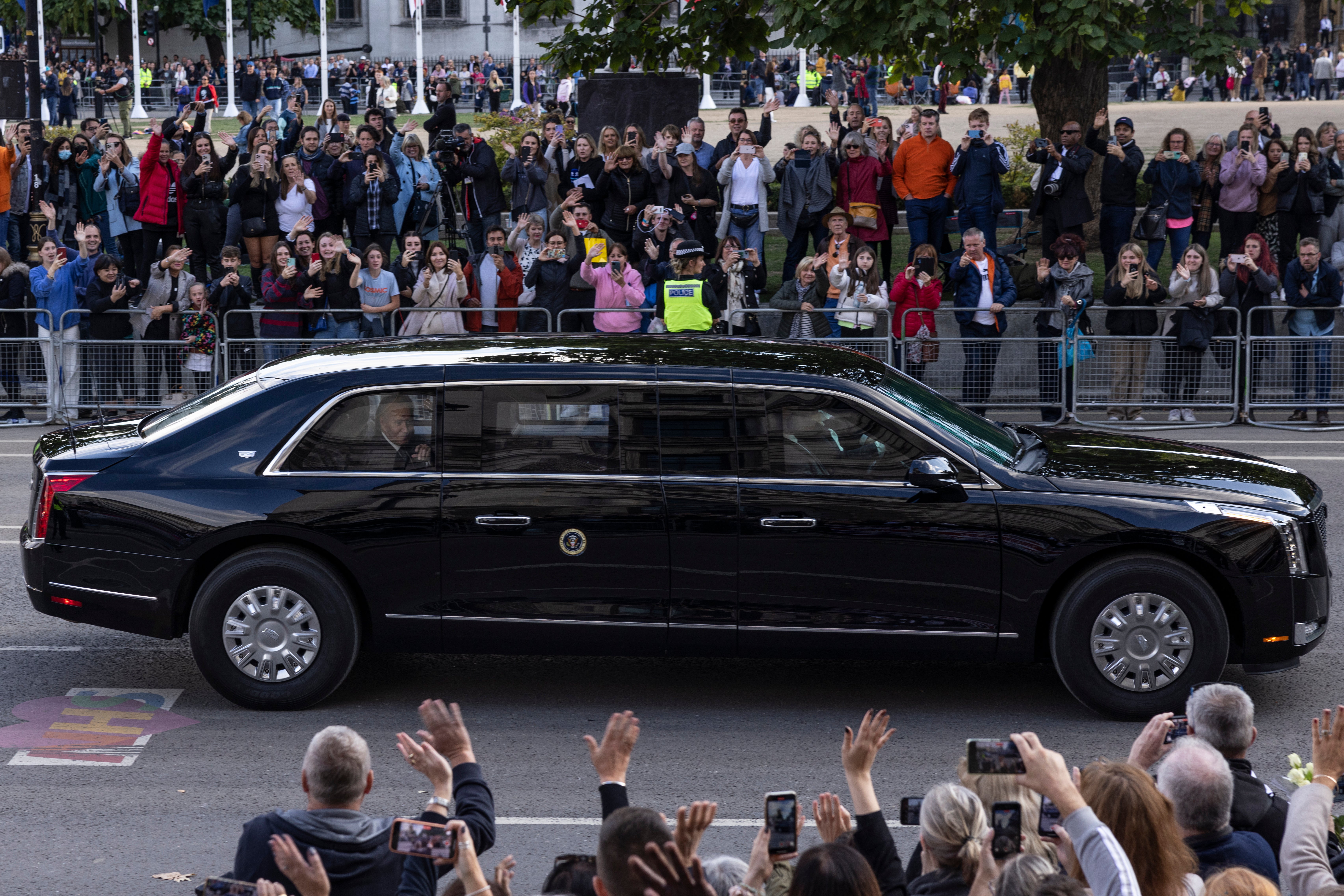 Joe Biden y la primera dama Jill Biden saludan a la multitud abordo de “La Bestia” mientras se dirigen al funeral de la reina