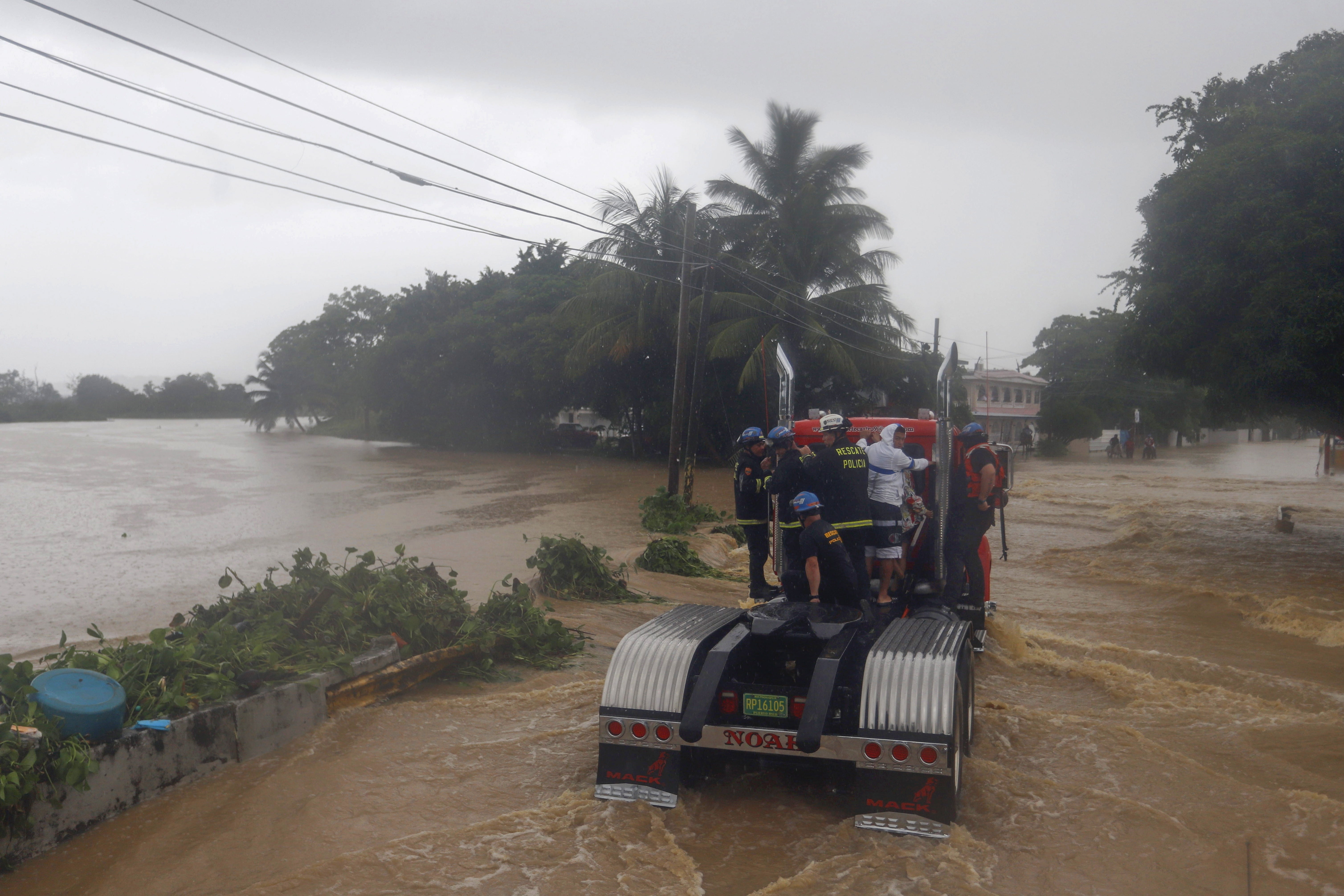 Miembros del equipo de rescatistas viajan sobre un tráiler para poder desplazarse en Puerto Rico el 19 de septiembre de 2022