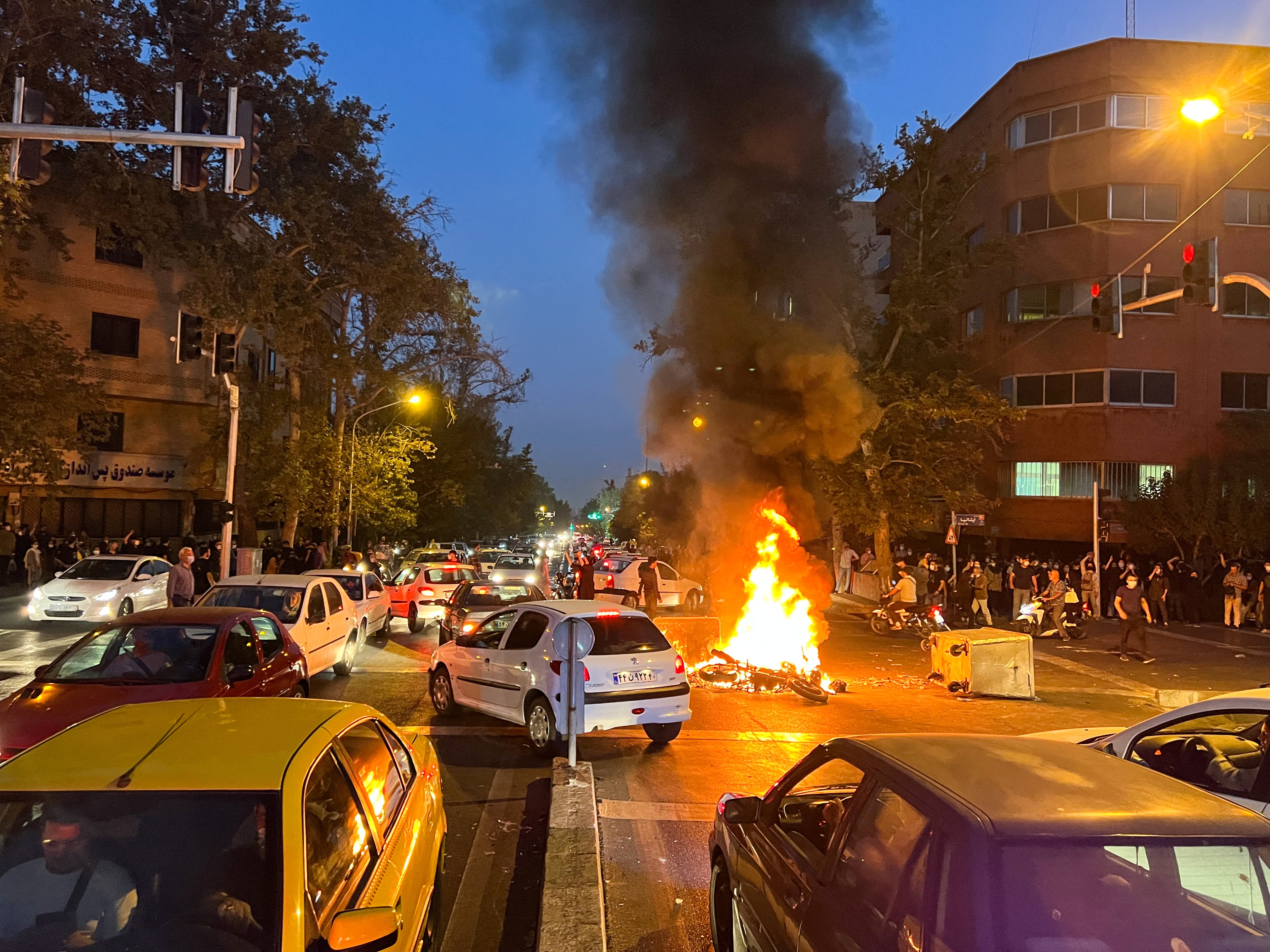Una motocicleta policial arde durante una protesta por la muerte de Mahsa Amin en Teherán