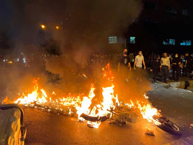 Una moto de la policía se quema durante una protesta por la muerte de Mahsa Amini