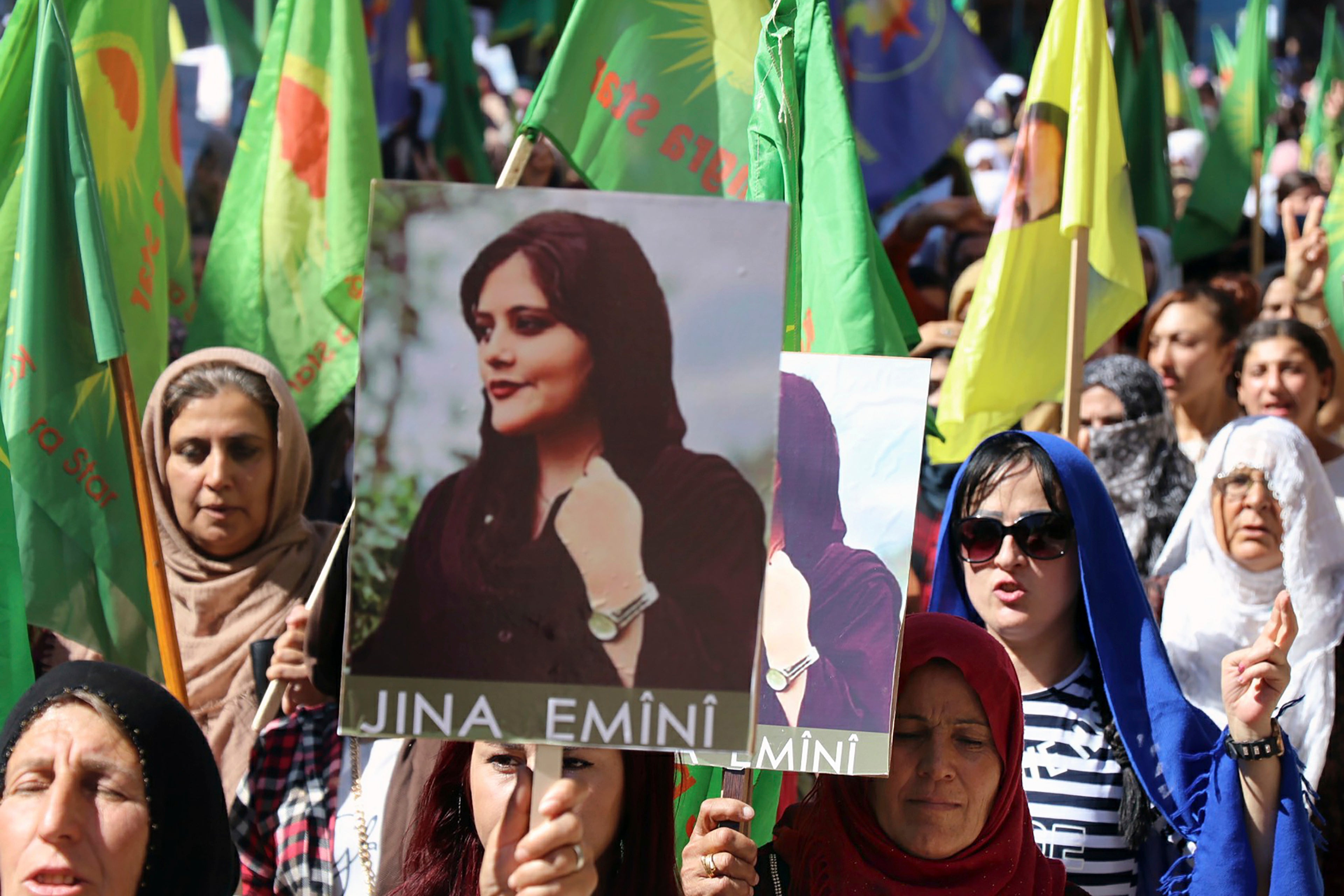 Mujeres kurdas sostienen retratos de Mahsa Amini durante una protesta en Qamishli, en el norte de Siria