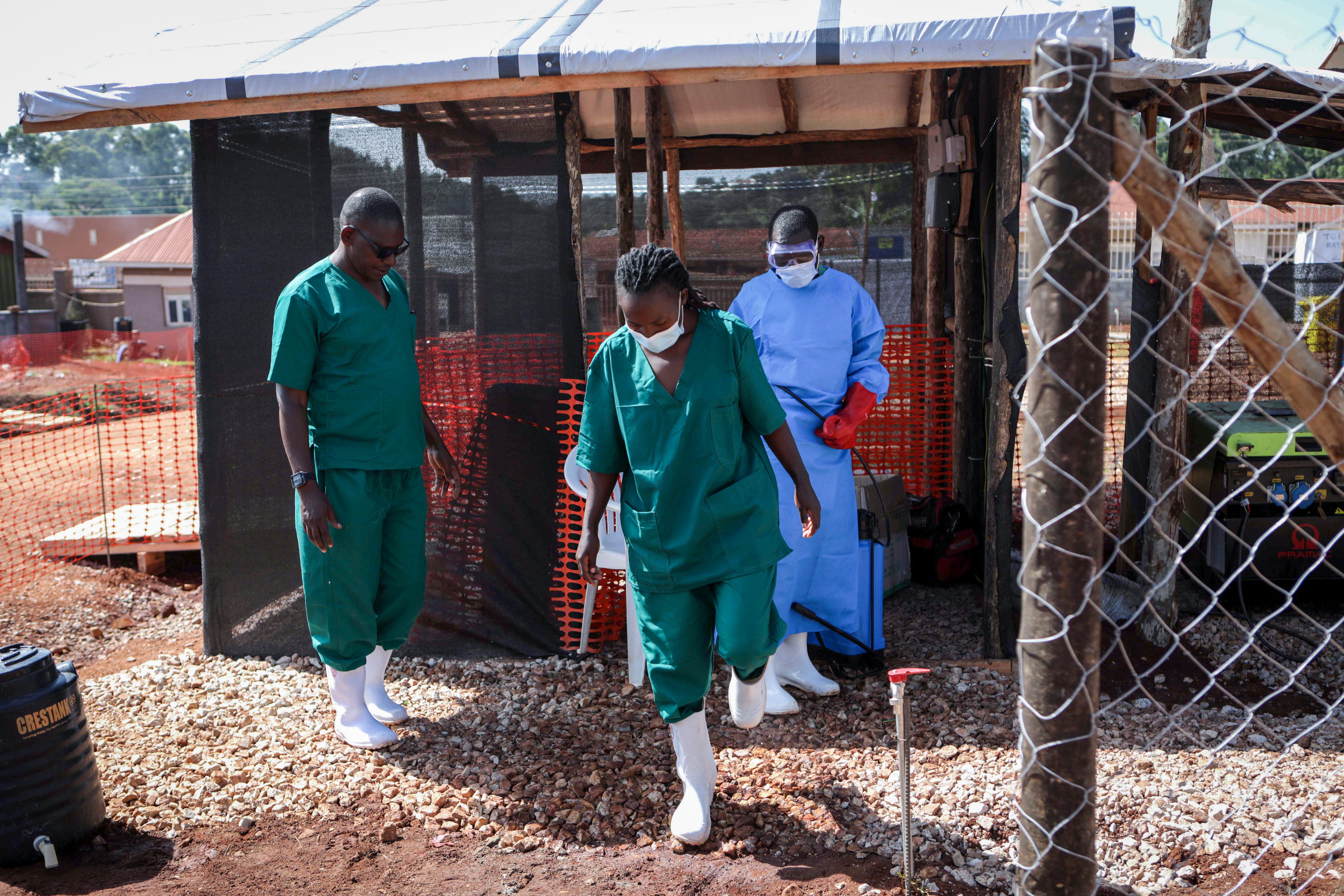 Un asistente médico desinfecta las botas de goma de un funcionario médico antes de abandonar la sección de aislamiento del ébola del Hospital Regional Especializado de Mubende, en Mubende, Uganda