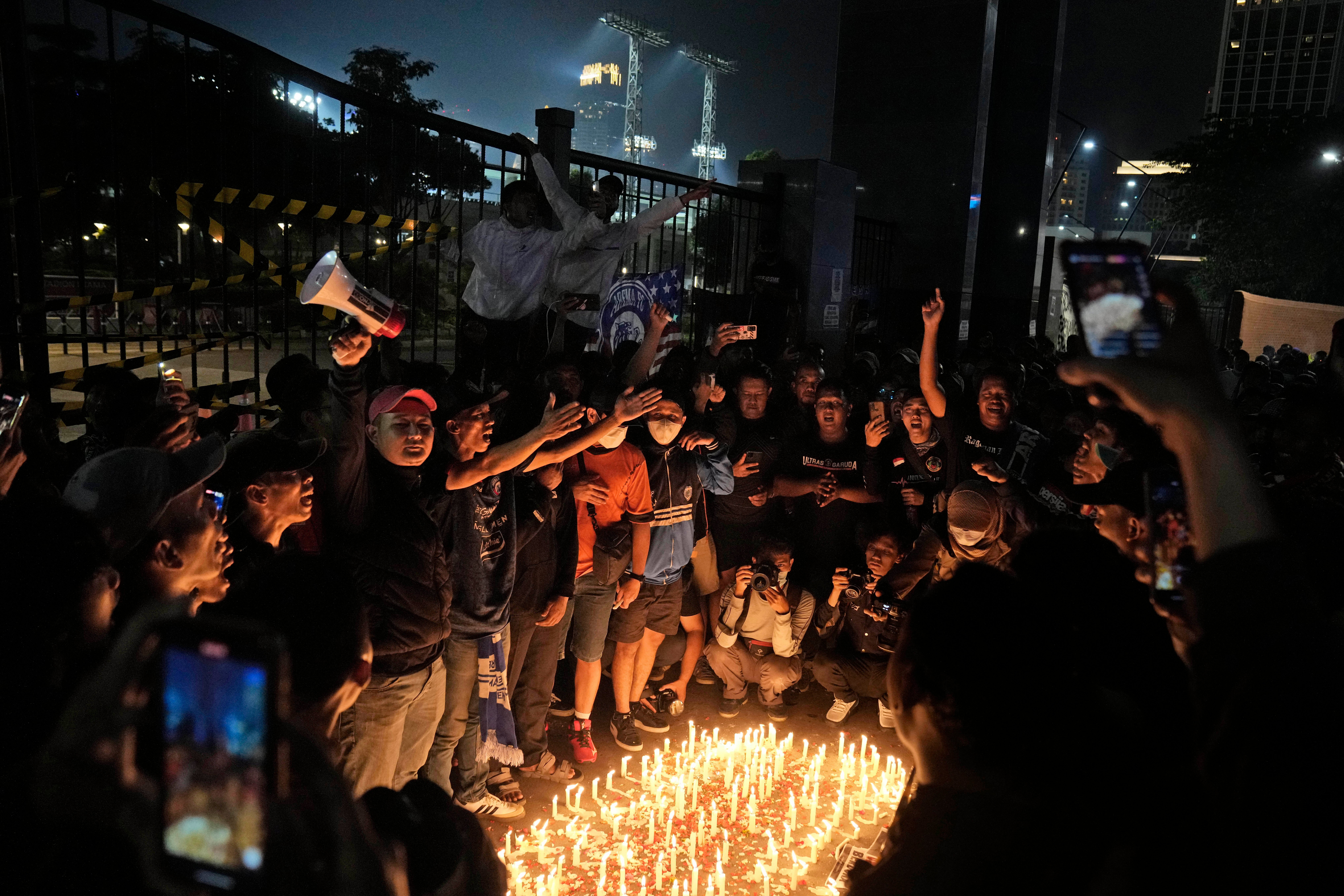 Aficionados realizan una vigilia por los muertos en la tragedia del estadio