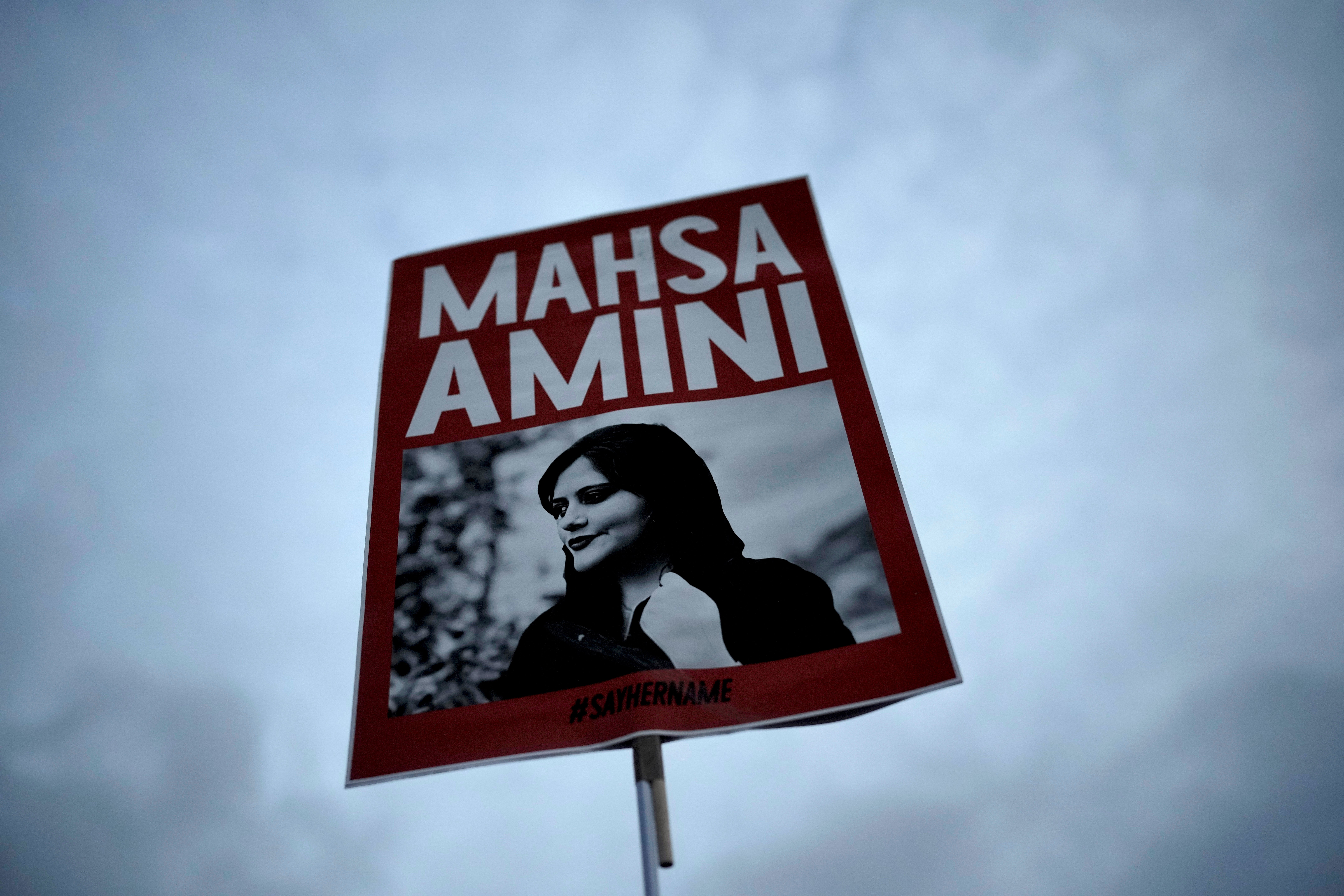 Una mujer sostiene una pancarta con una foto de Mahsa Amini mientras asiste a una protesta en Berlín, Alemania