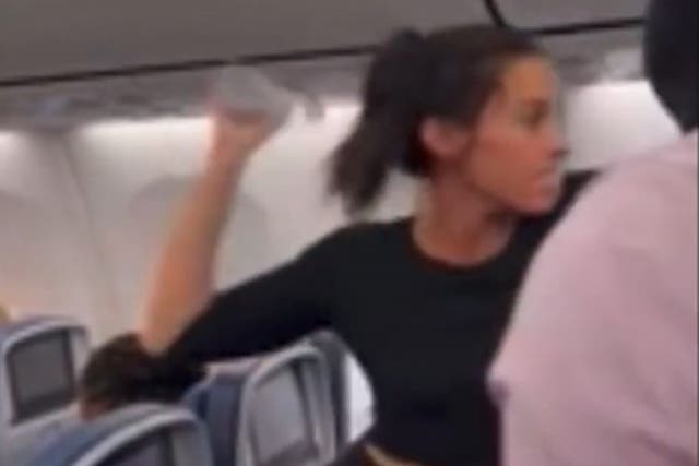 En un momento, la mujer arrojó su botella de agua a una fila de pasajeros detrás de ella.