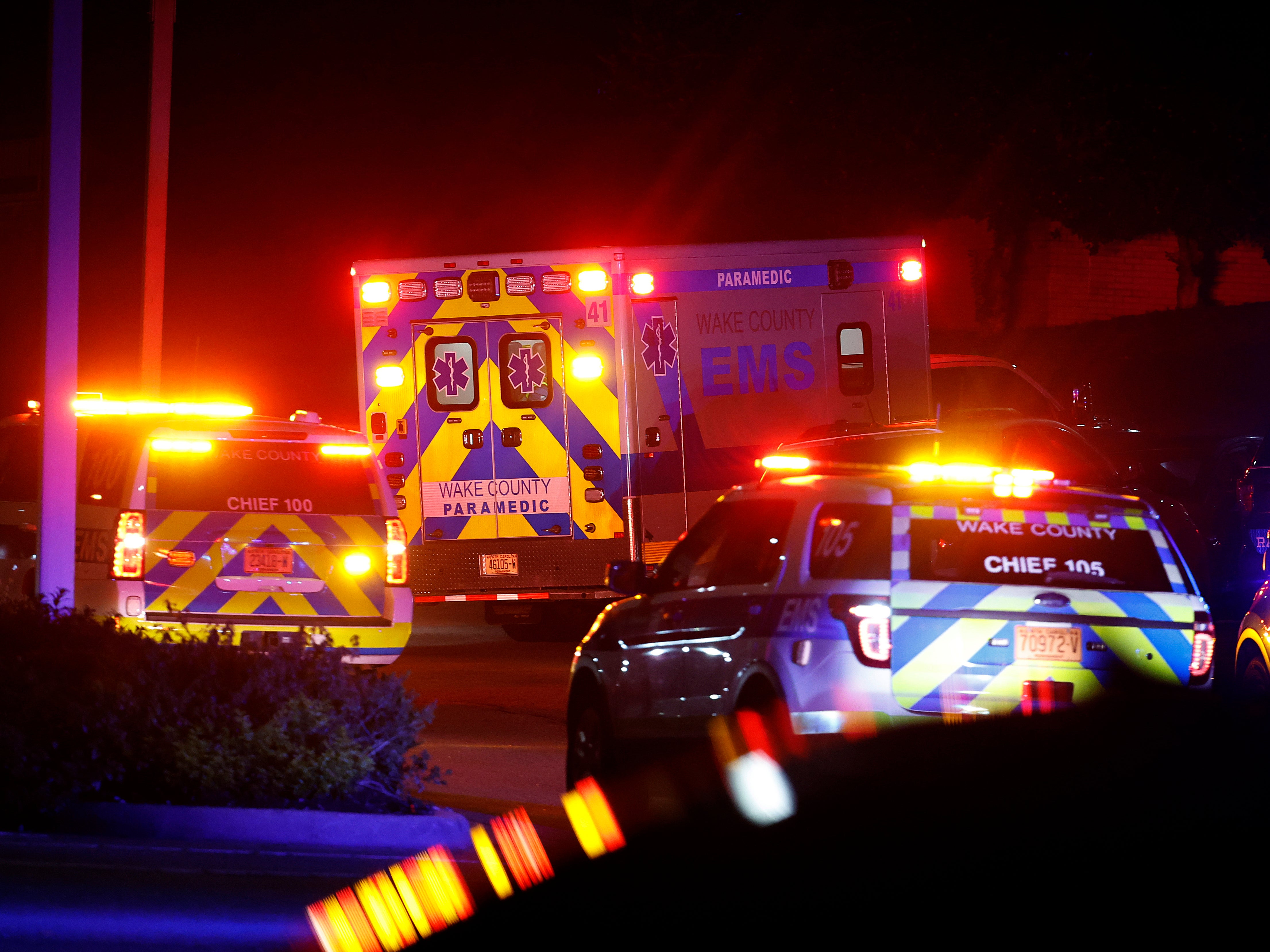 Una ambulancia en la que se cree que iba el sospechoso llega a la Sala de Urgencias del Centro Médico Wake en Raleigh, Carolina del Norte, rodeada de policías, el jueves 13 de octubre de 2022